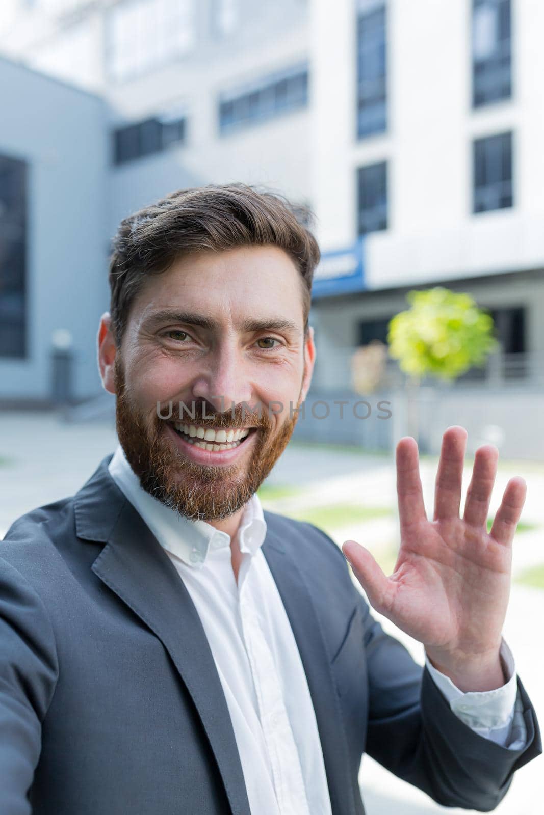 vertical view smartphone camera Caucasian bearded businessman speaks on phone using a front camera on a video call. employee business man talking on webcam. Conversation of an office worker in suit