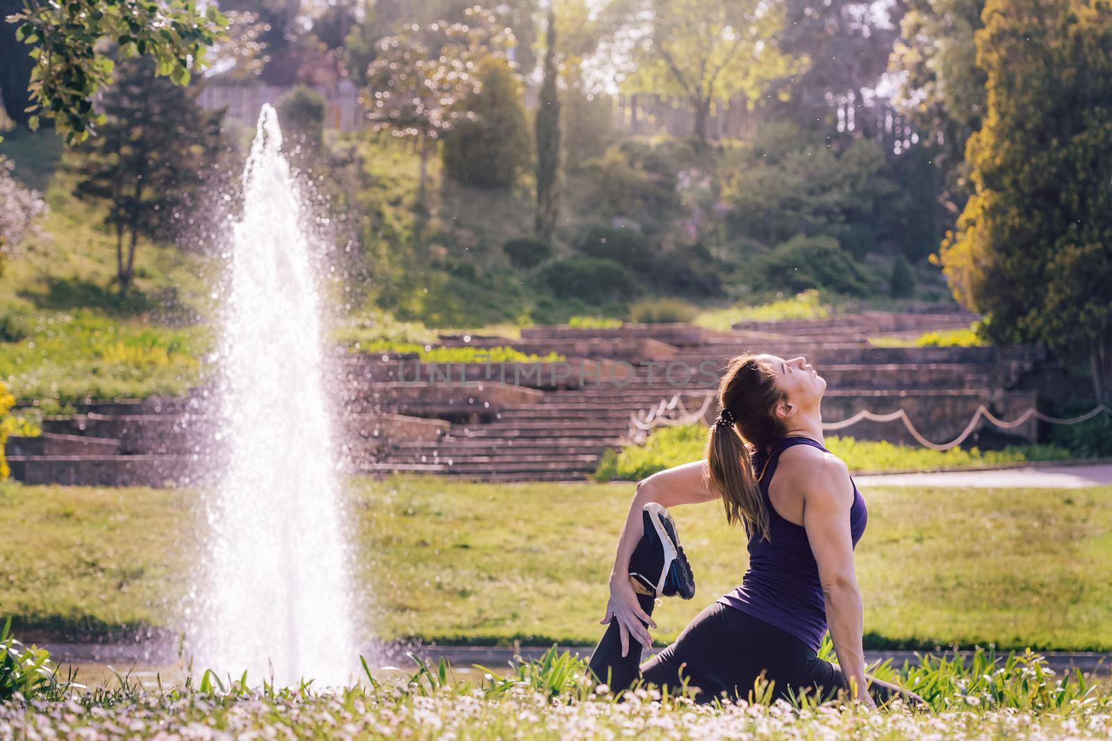 young woman doing yoga exercises in the park by raulmelldo