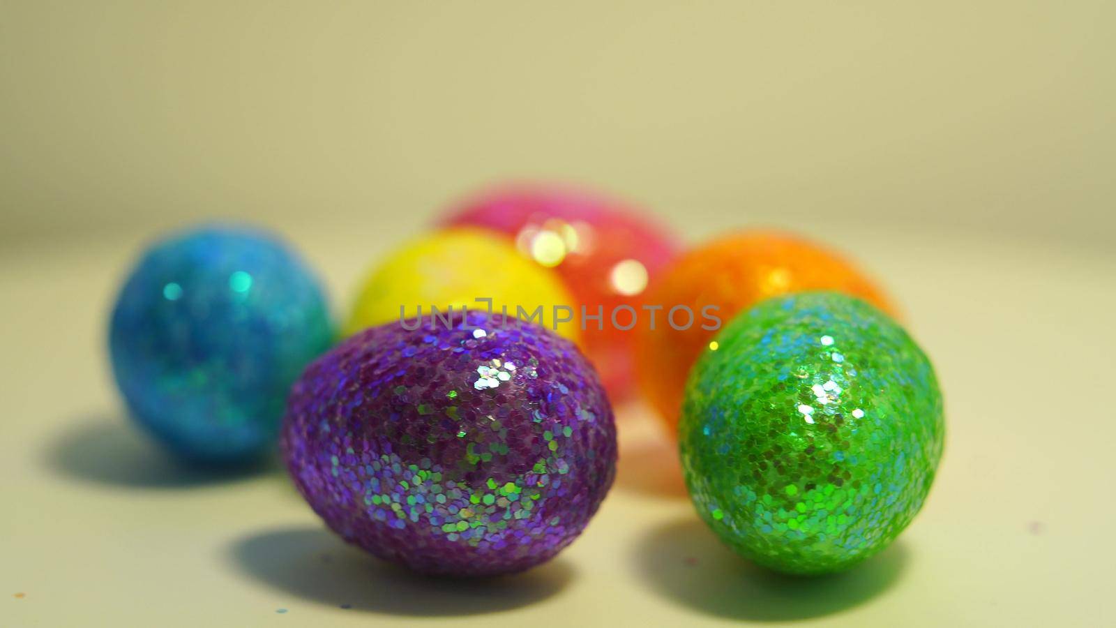 Colorful Easter eggs rotating in rows in a seamless loop on a light background.