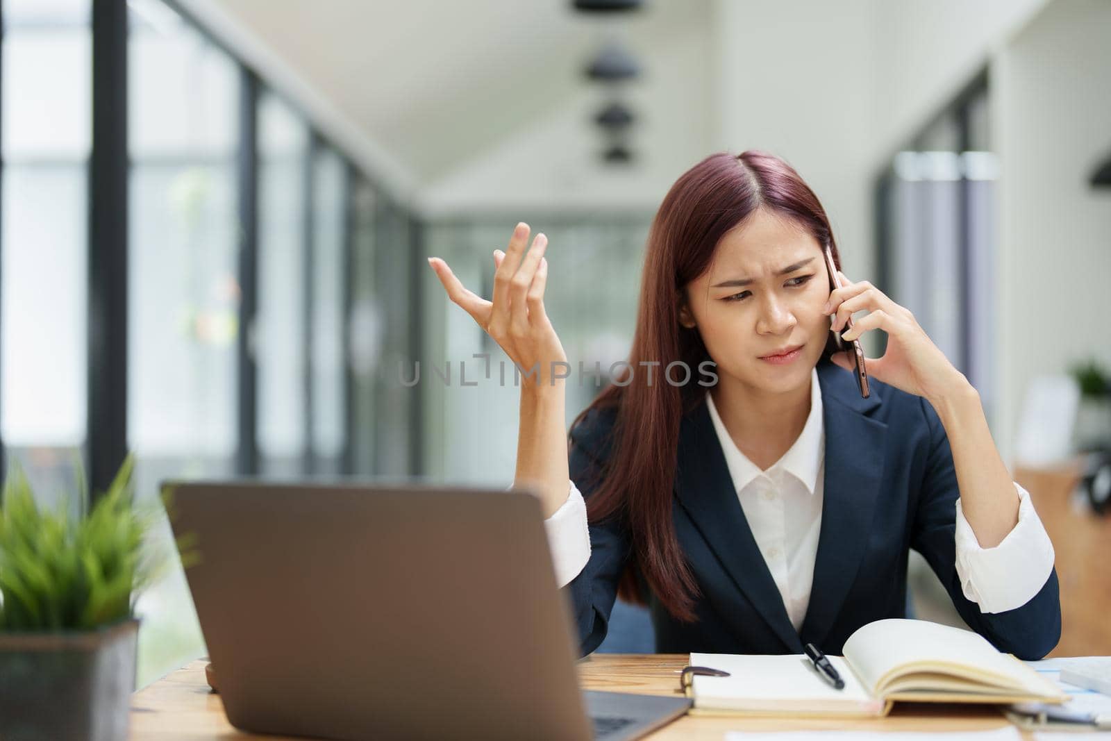 businesswoman showing a serious expression while talking on the phone.