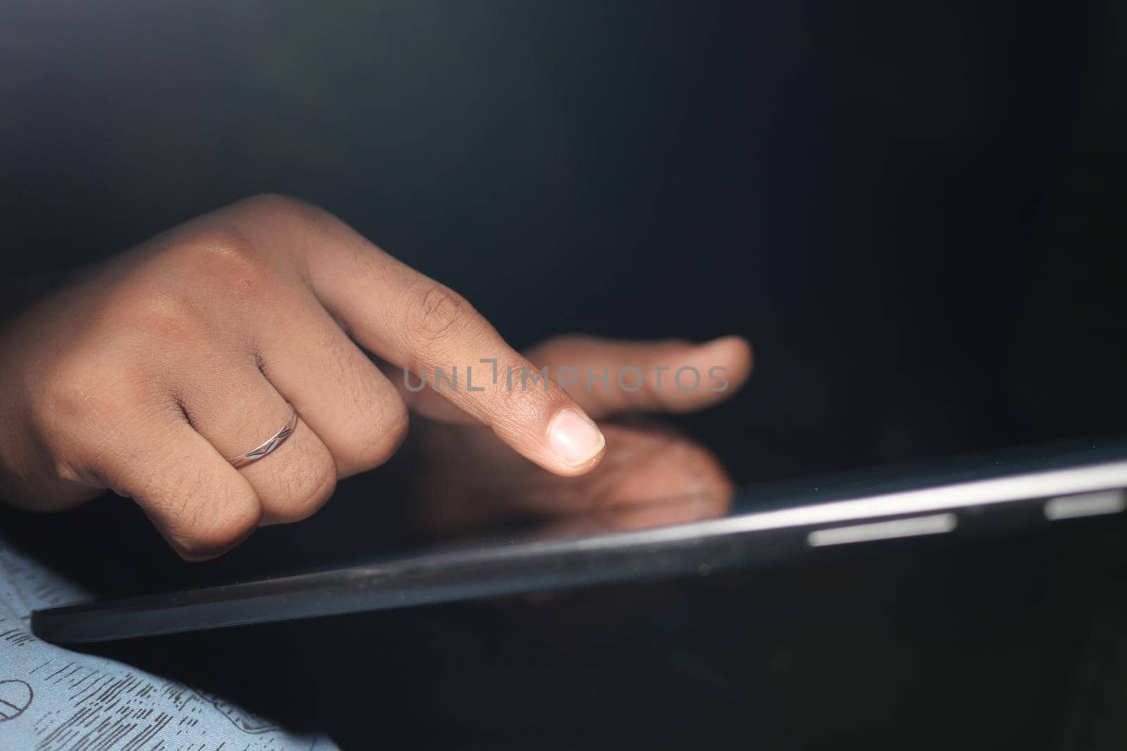 man hand using digital tablet on black background .
