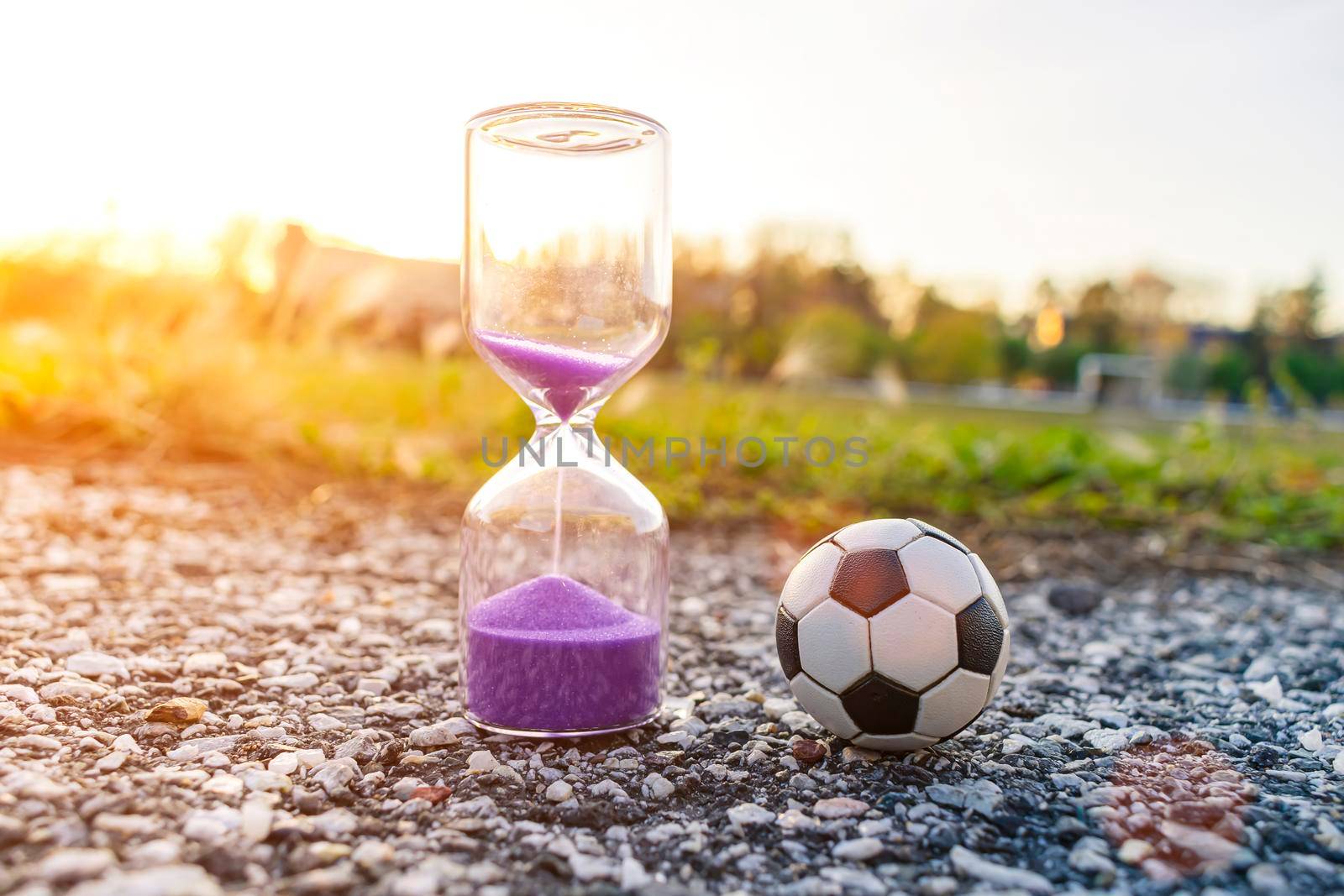 Soccer ball and hourglass symbolizing football time. The concept of sports for everyone and everywhere