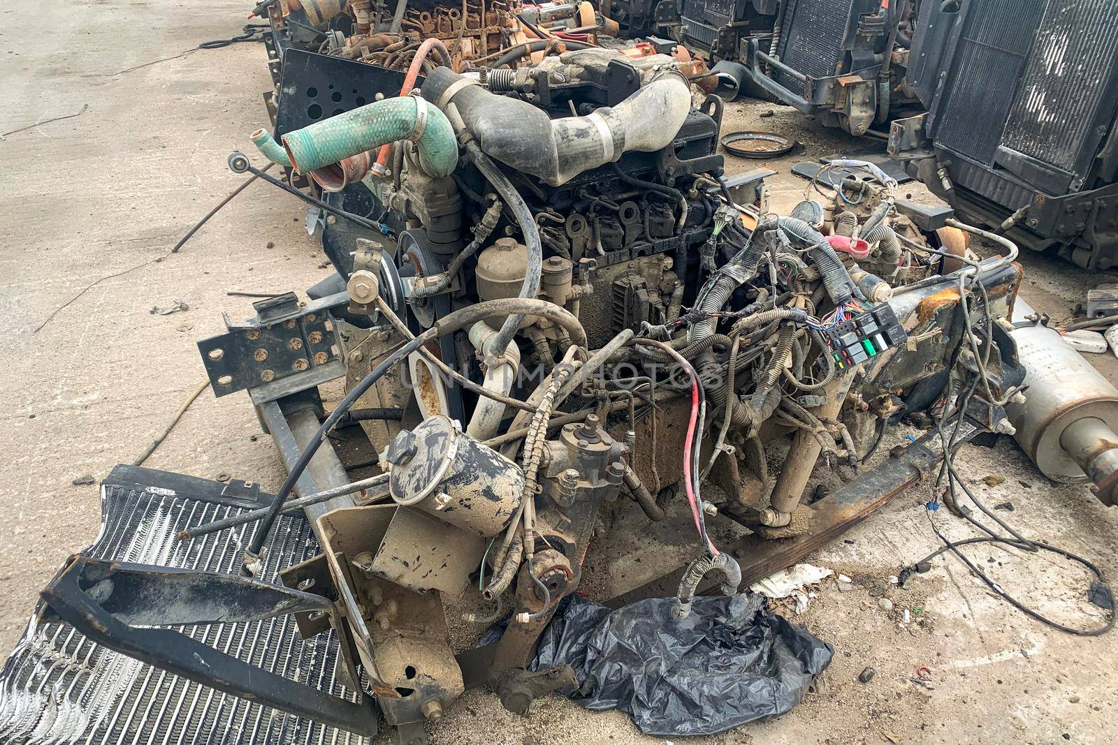 Closeup of internal combustion engine removed from a car and resting on the ground in a automotive wrecking