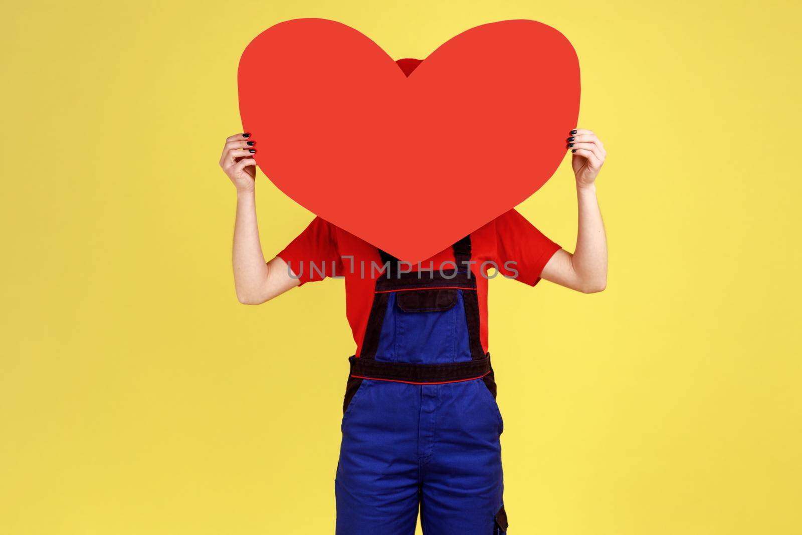 Worker woman hiding her face behind big red heart, expressing romantic feelings. by Khosro1