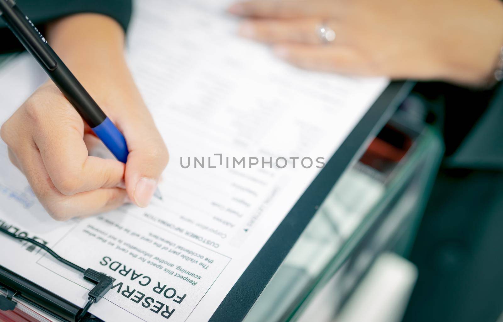 Business people hand holding pen and fill corporation profile in paper form for contract agreement, and complete deal. Document work or paperwork. Contract and agreement document on desk. Deal concept