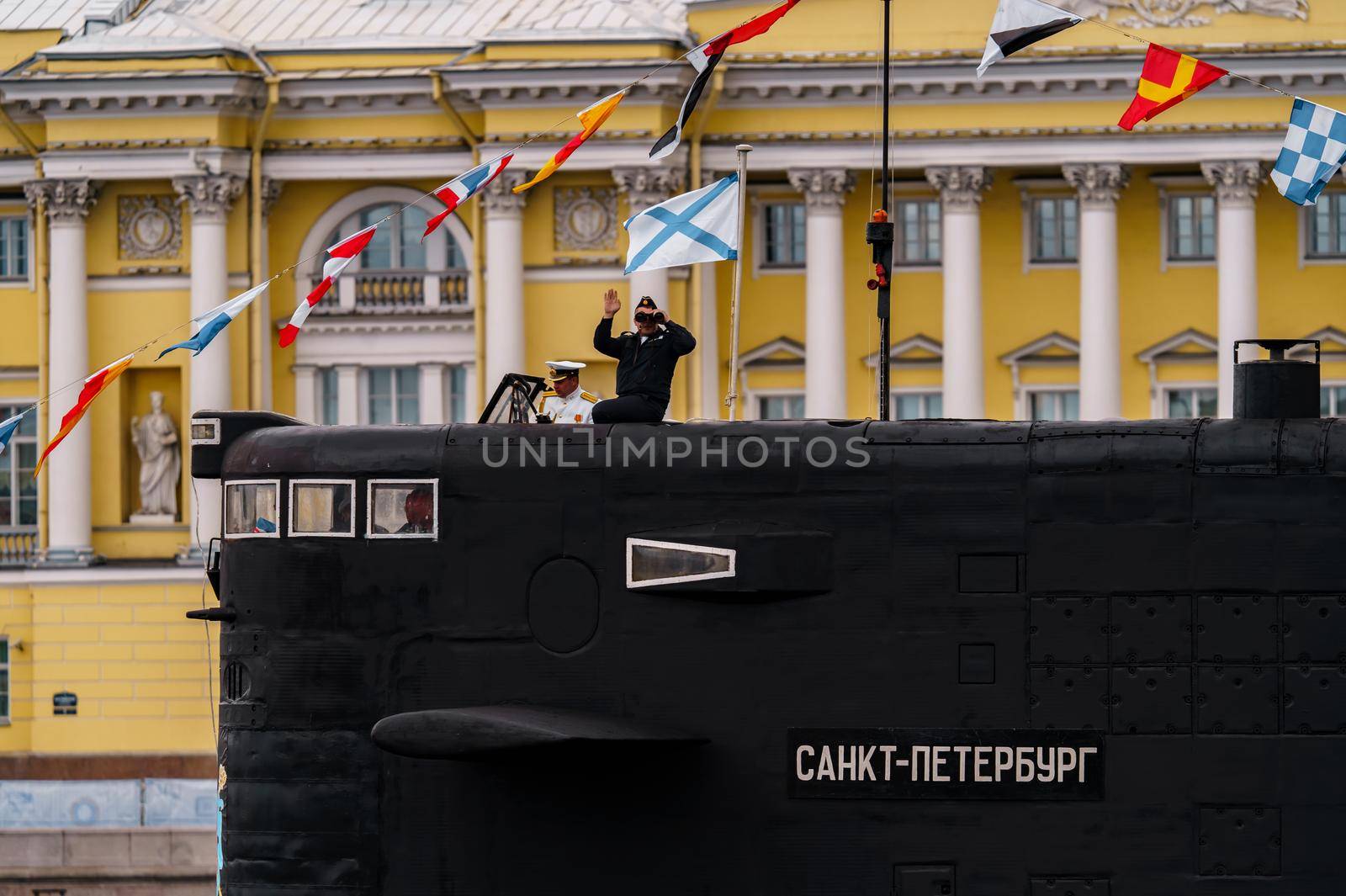 Russia, St. Petersburg, 31 July 2022: The commander of a submarine standing in the center of the city looks through binoculars, he is dressed in a festive white uniform, celebration of the day of Navy. High quality photo