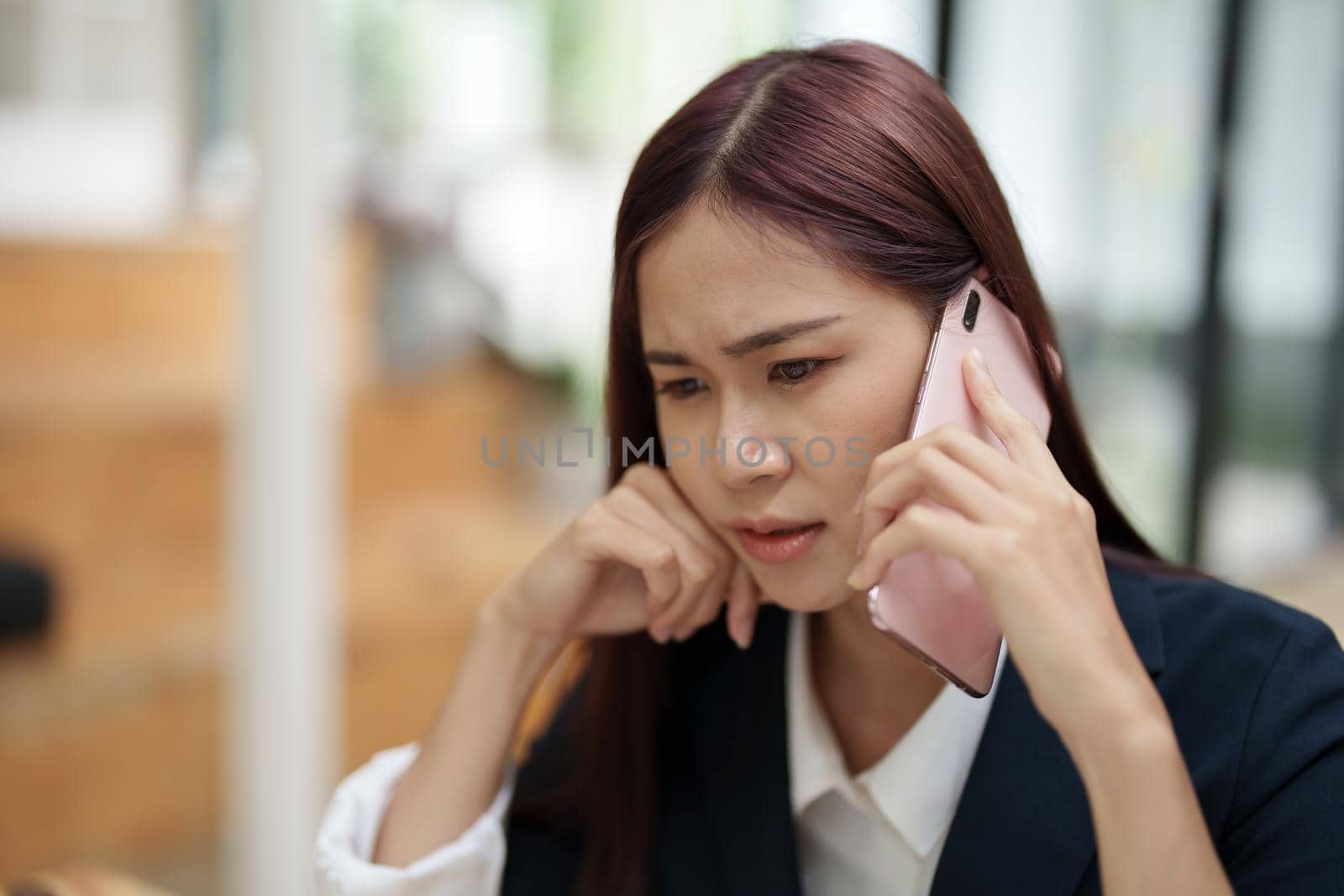 businesswoman showing a serious expression while talking on the phone.