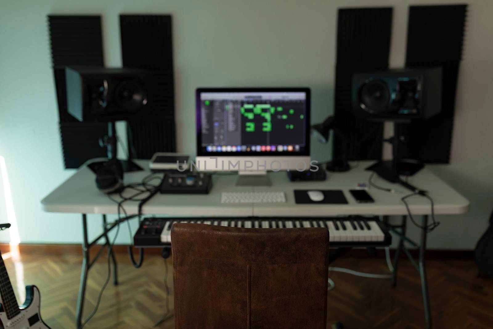 The chair of a music producer dominates the scene amongst the other tools that conform an average home studio