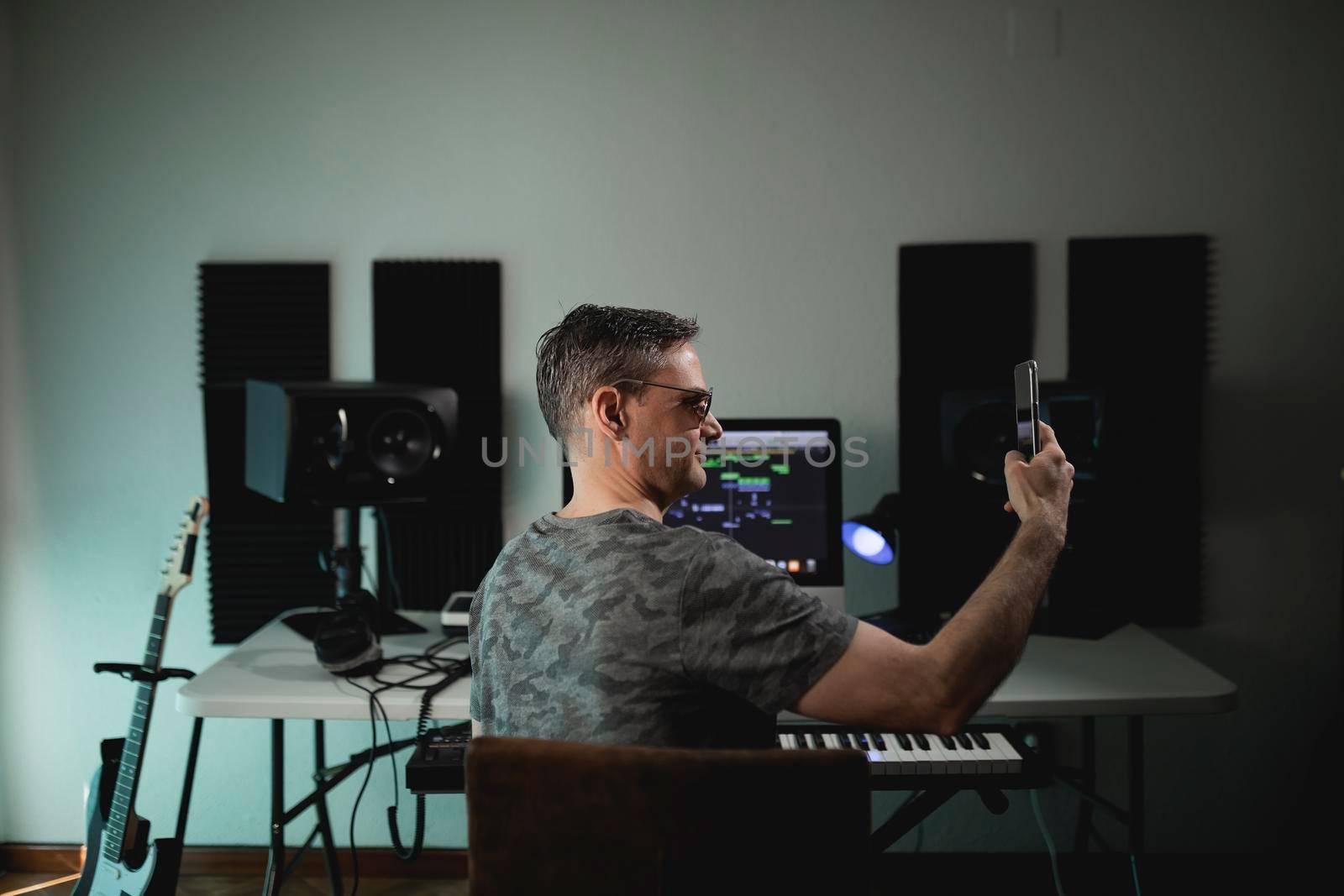 Portrait of a music producer at his home studio while taking a selfie by stockrojoverdeyazul