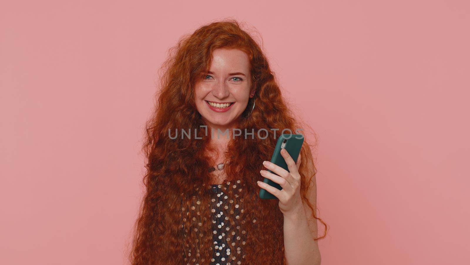 Happy excited joyful young woman in polkadot dress use mobile cell phone typing browsing shouting say wow yes found out great big win, good news, lottery goal achievemen, celebrating success, winning