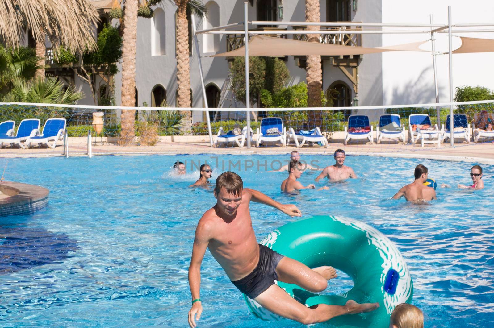 young people playing volleyball with a ball on the water in the pool during the summer holidays Sharm el Sheikh, Egypt, June 6, 2012.