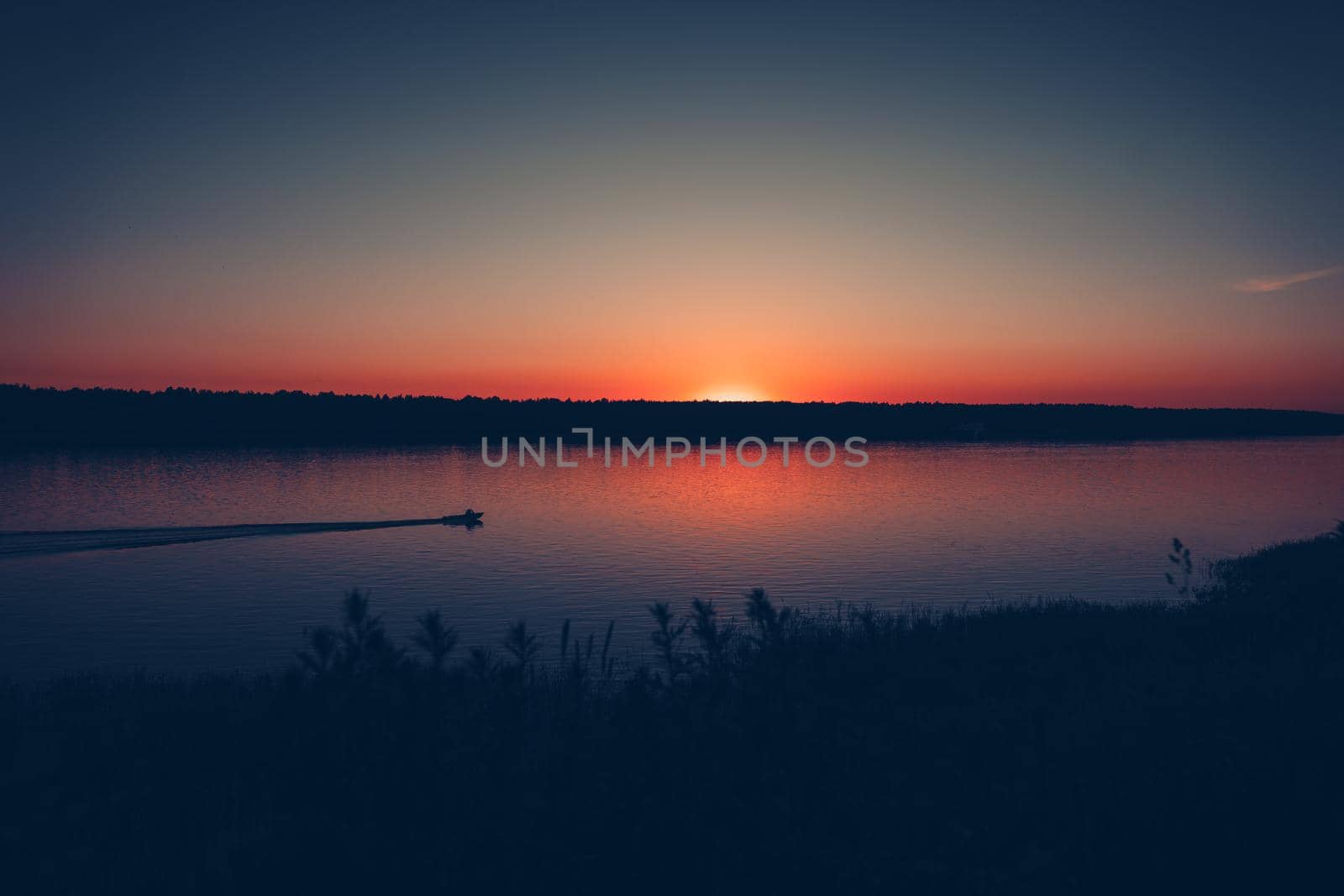The boat floats on the water at sunset. High quality photo