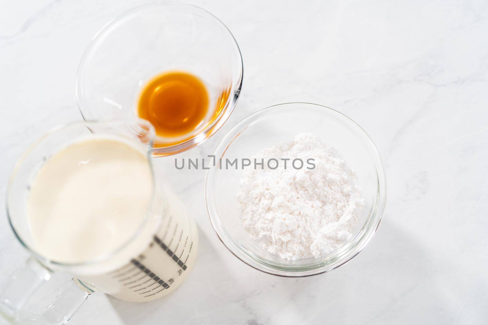 Measured ingredients in glass mixing bowls to prepare the homemade whipped cream.