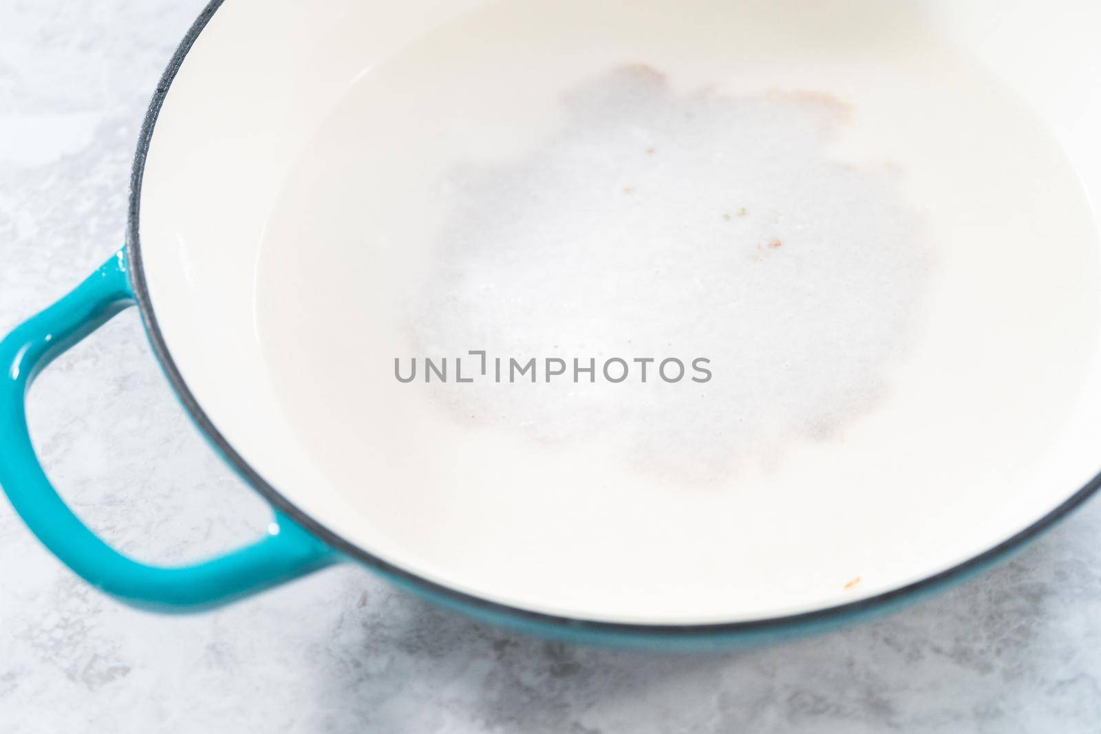 Cleaning cast iron enameled braiser with baking soda and vinegar.