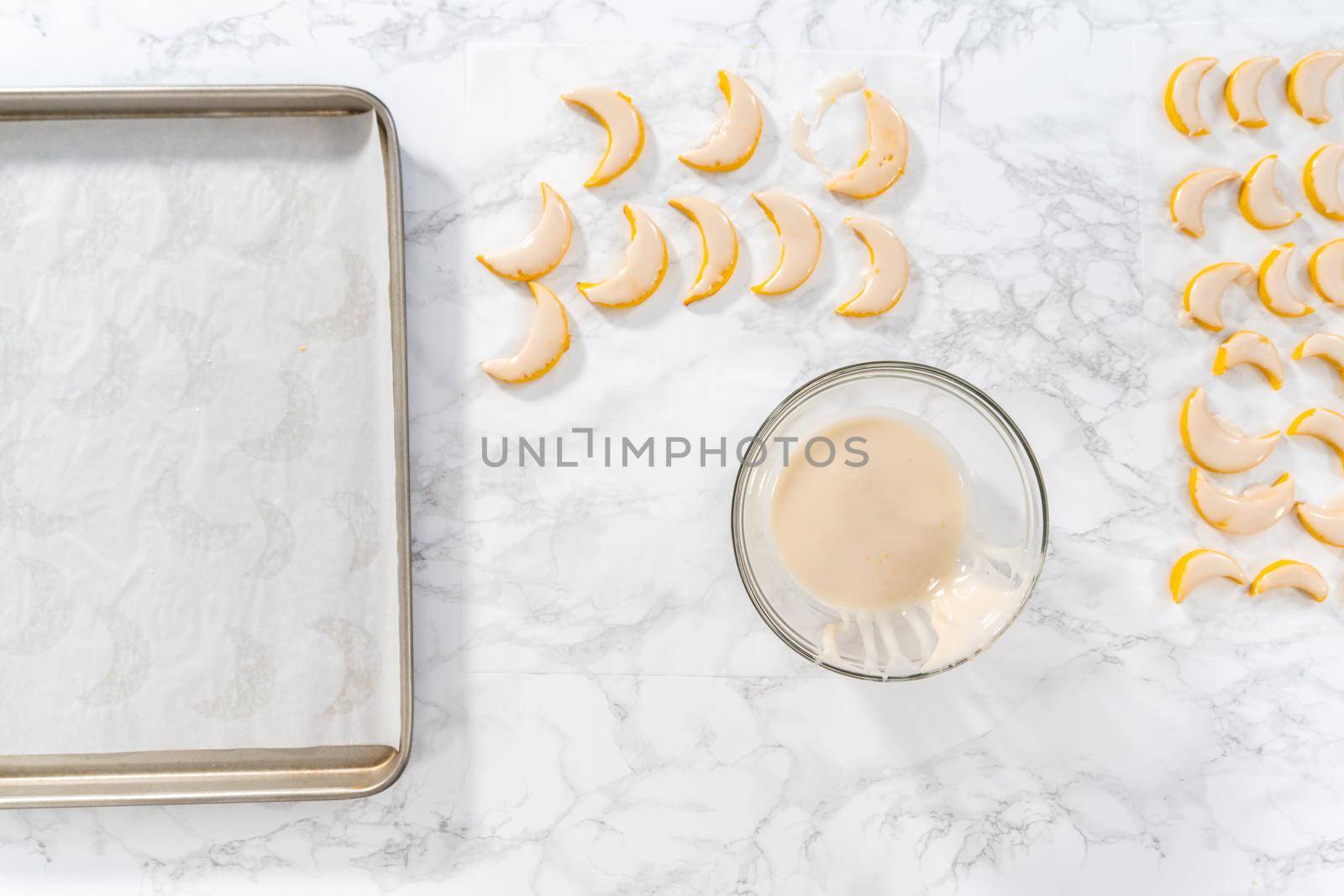 Flat lay. Lemon wedge cookies with lemon glaze. Dipping lemon cookies into a lemon glaze.