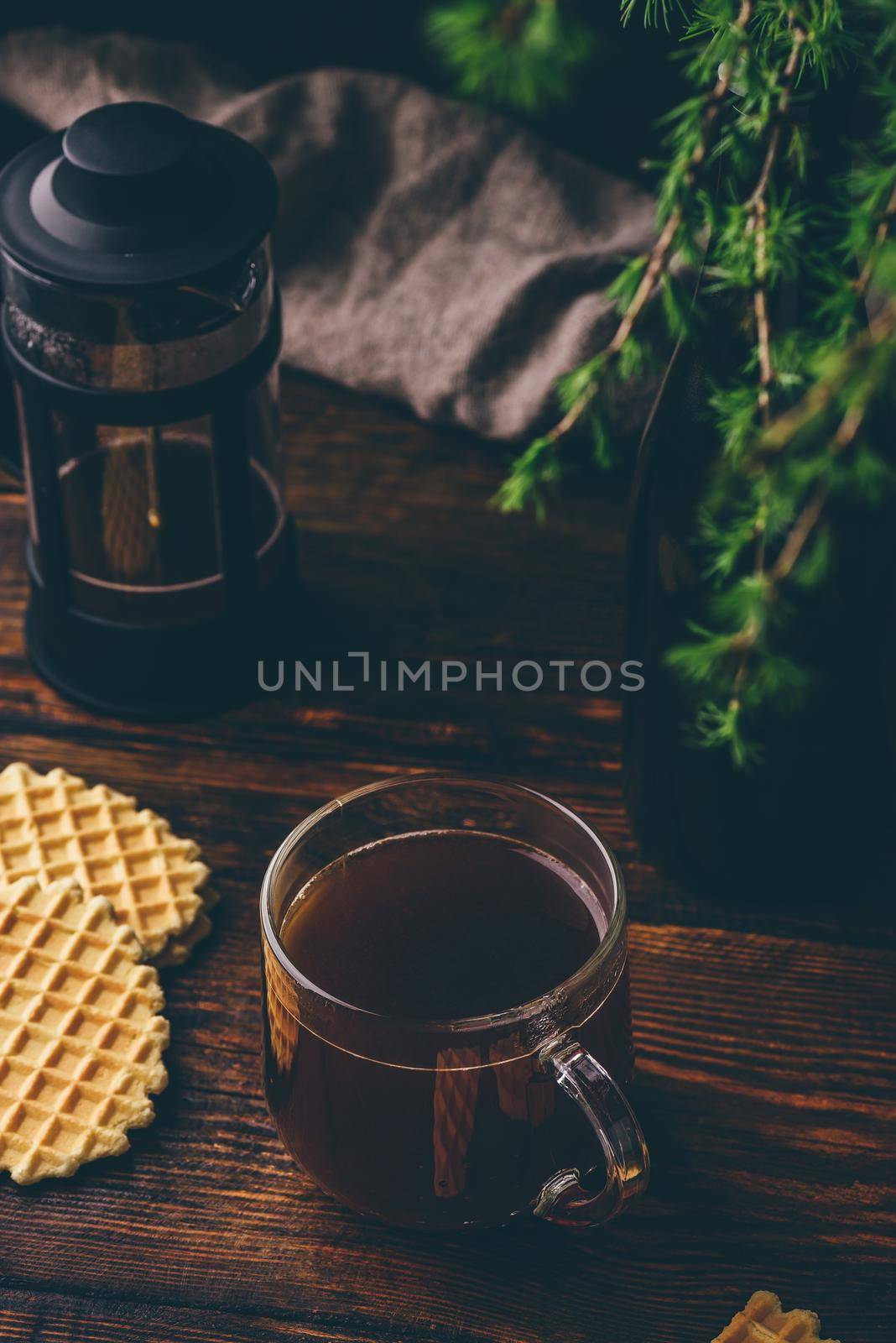 Cup of coffee brewed in french press with cookies on rustic wooden table