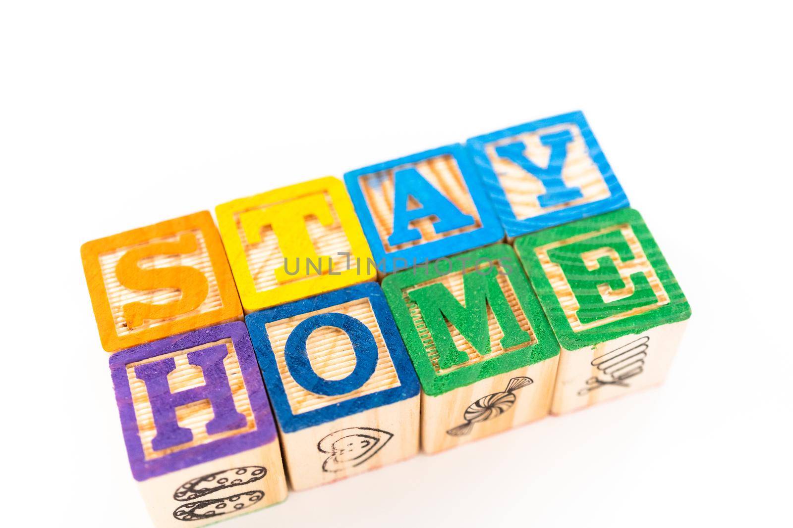 STAY HOME sign out of kids' alphabet blocks on a white background.