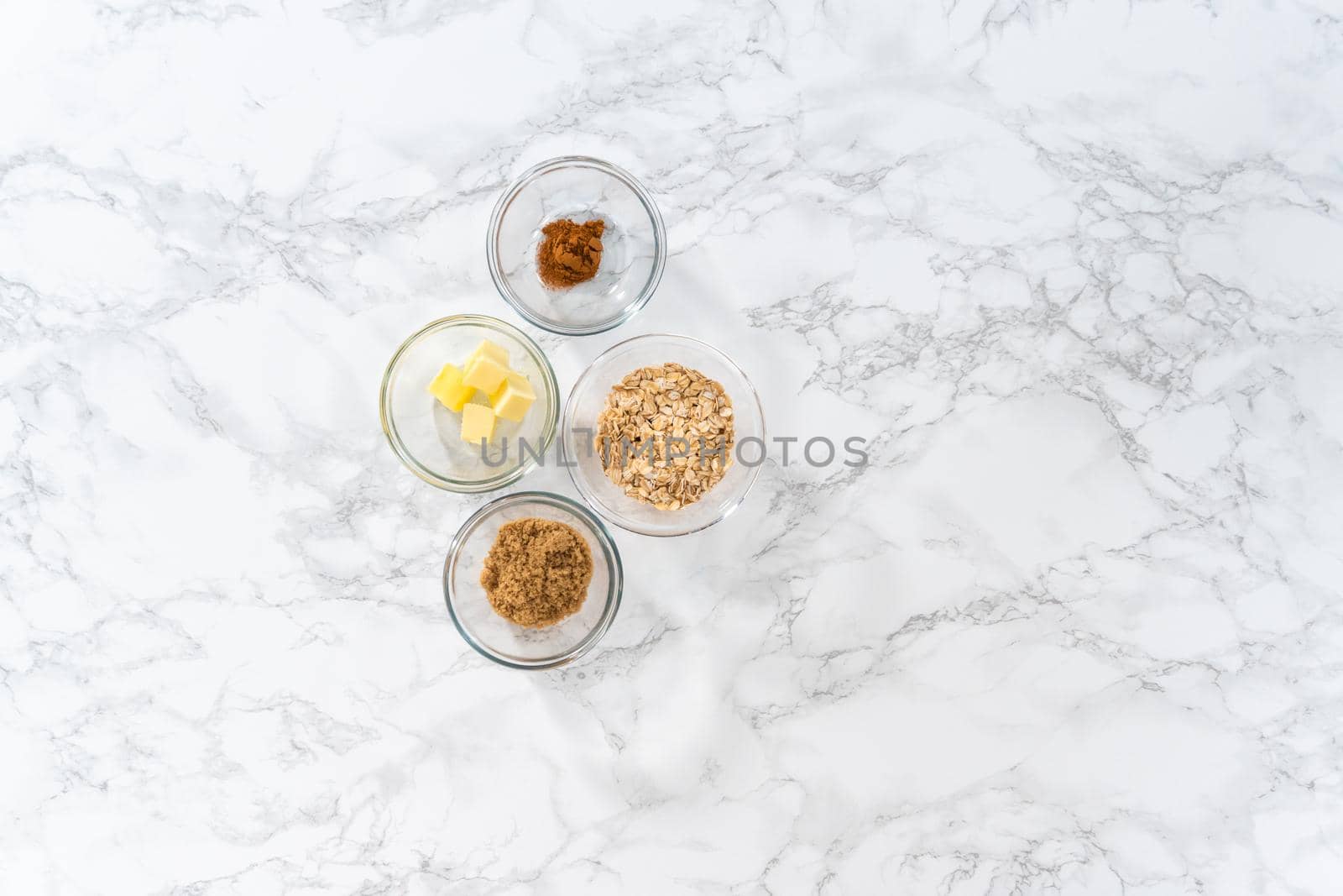 Flat lay. Measured ingredients in glass mixing bowls to bake banana oatmeal muffins.