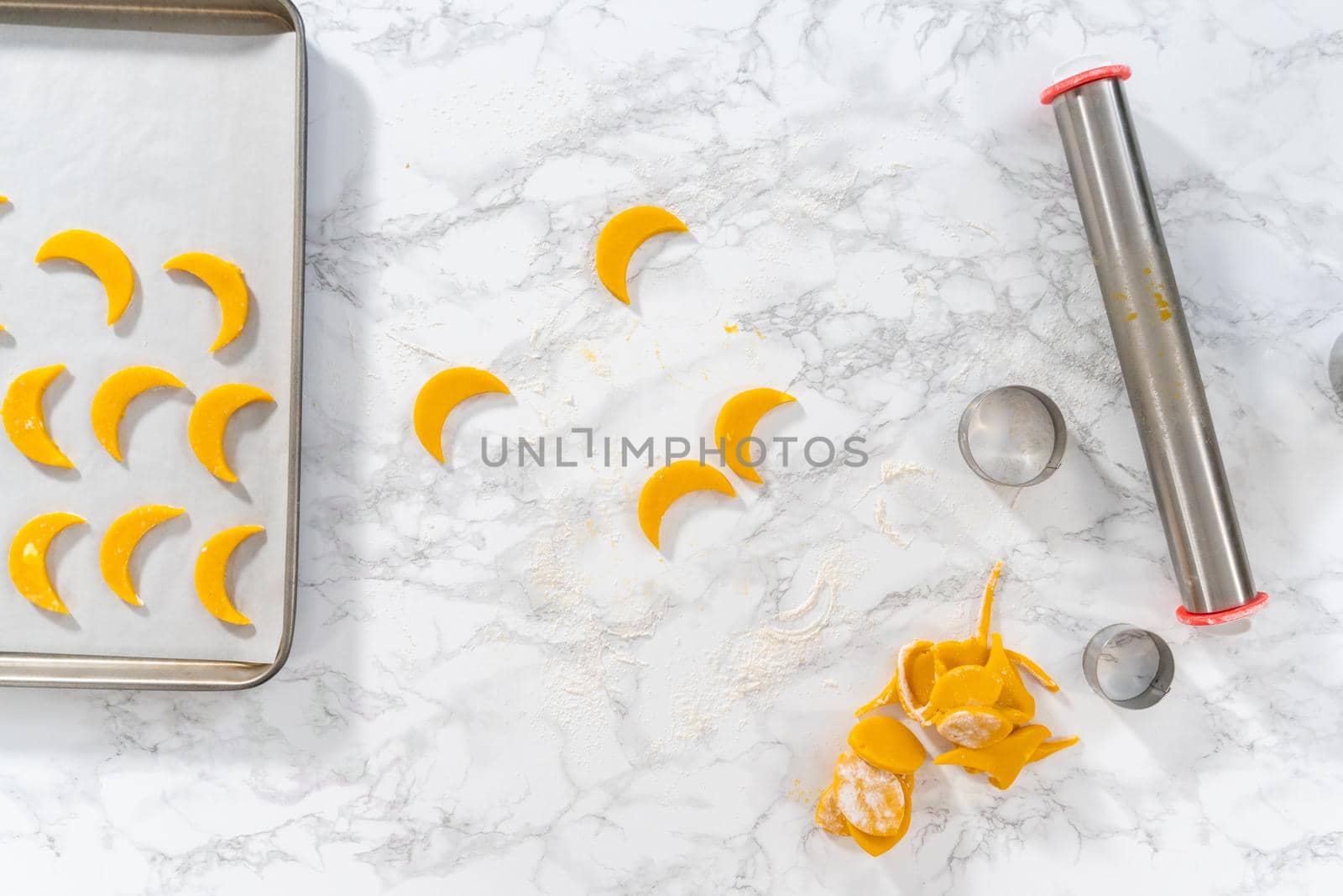 Flat lay. Lemon wedge cookies with lemon glaze. Rolling cookie dough with an adjustable rolling pin and cutting out cookies with cookie cutters to bake lemon wedge cookies with lemon glaze.