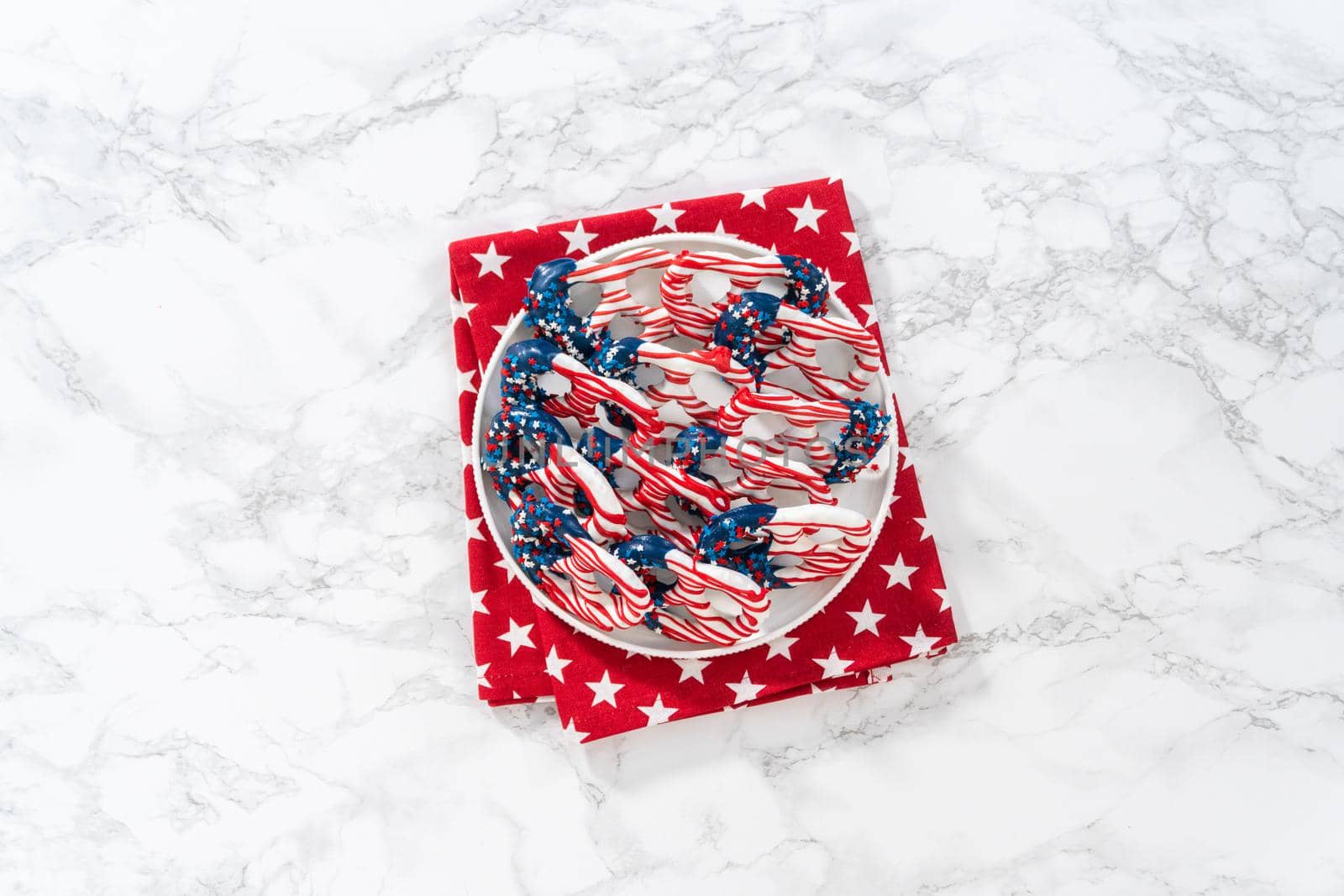 Flat lay. American flag. Red, white, and blue chocolate-covered pretzel twists.