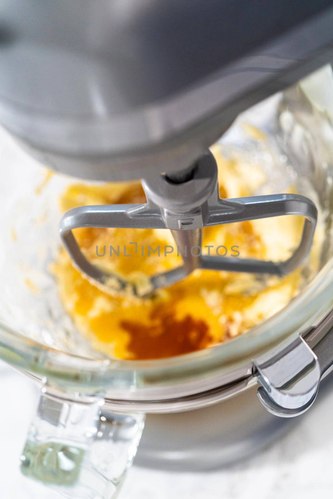 Mixing ingredients in a kitchen stand mixer to bake soft oatmeal raisin walnut cookies.