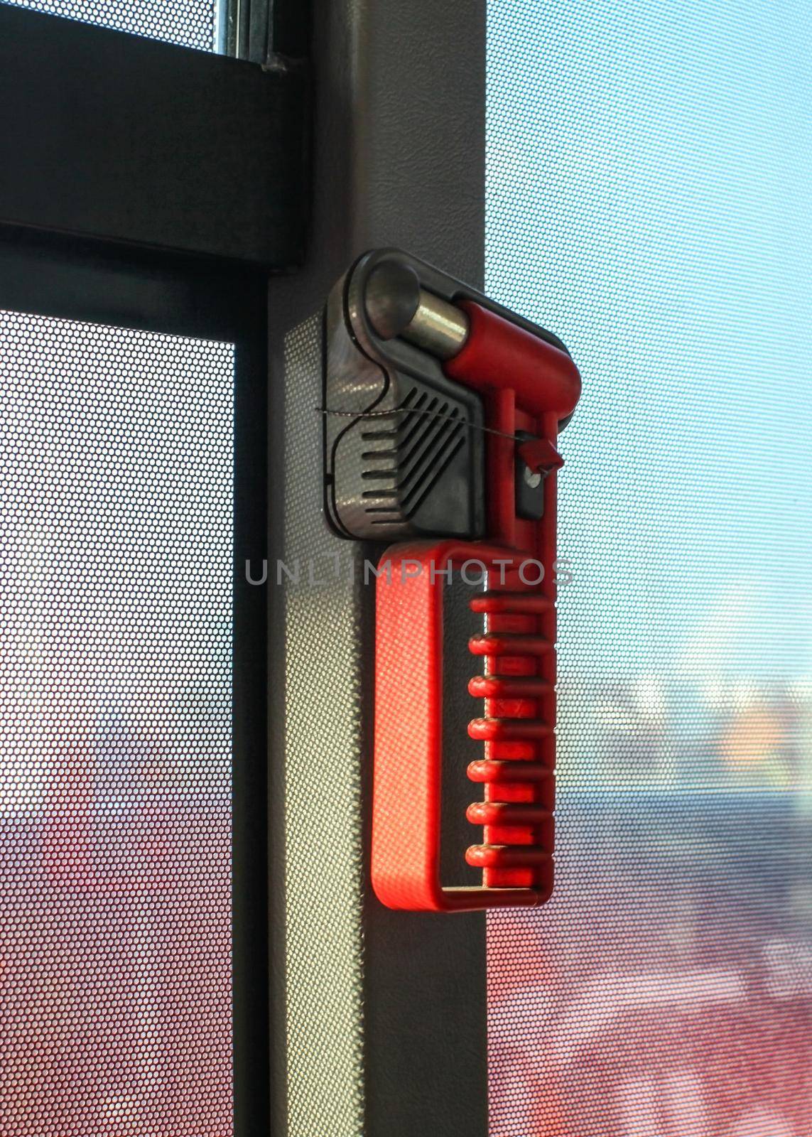 Red hammer, for breaking the window during emergency evacuation, on public bus window. by Ivanko