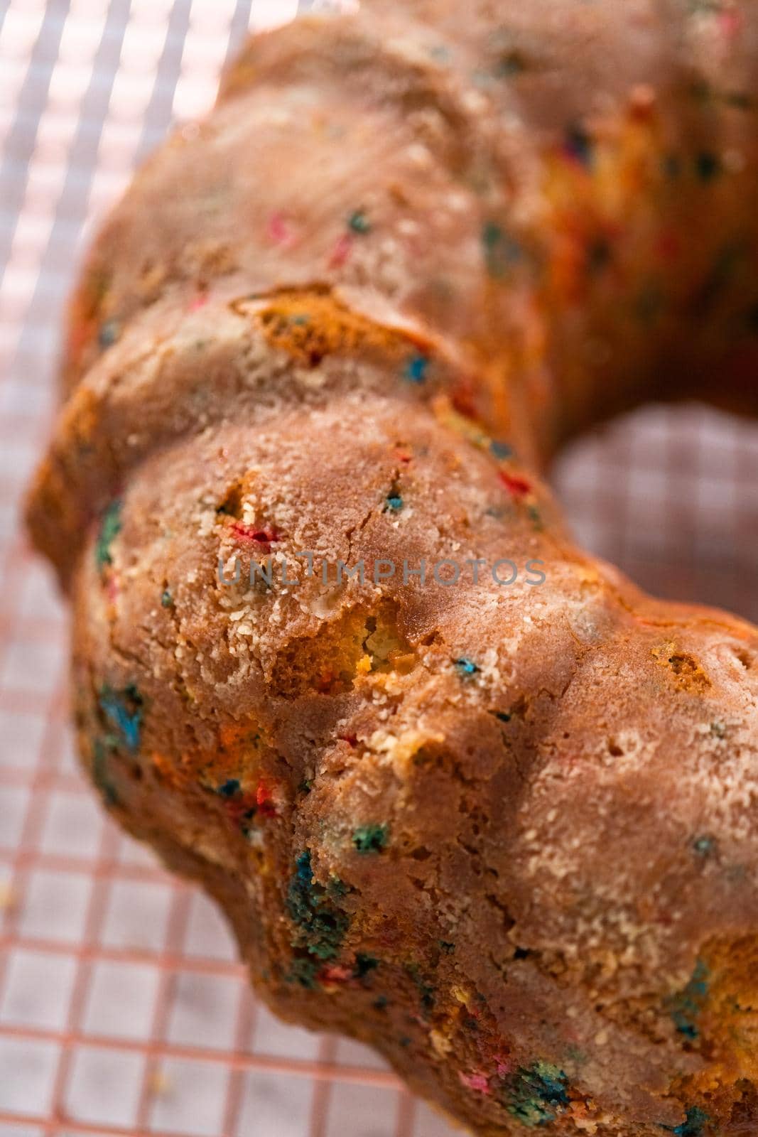 Close up view. Cooling freshly baked funfettti bundt cake on a wire rack.