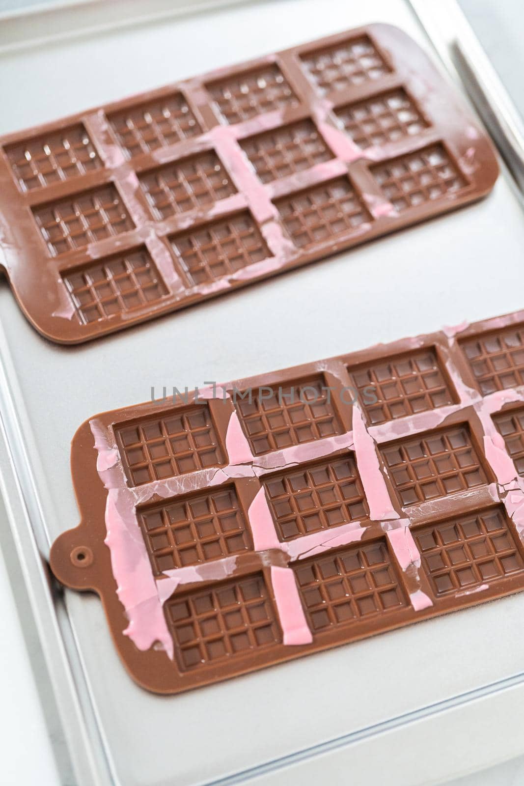 Removing mini pink chocolates from silicone chocolate mold.