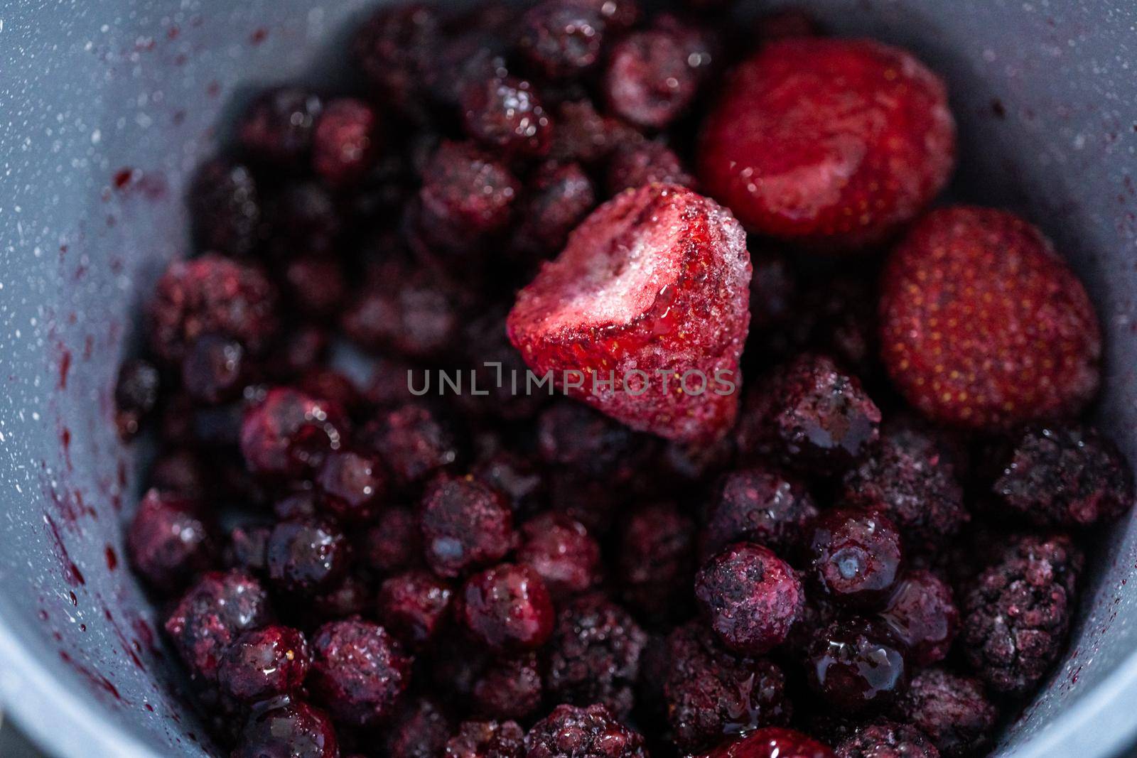 Preparing mixed berry compote from frozen berries in a nonstick cooking pot.