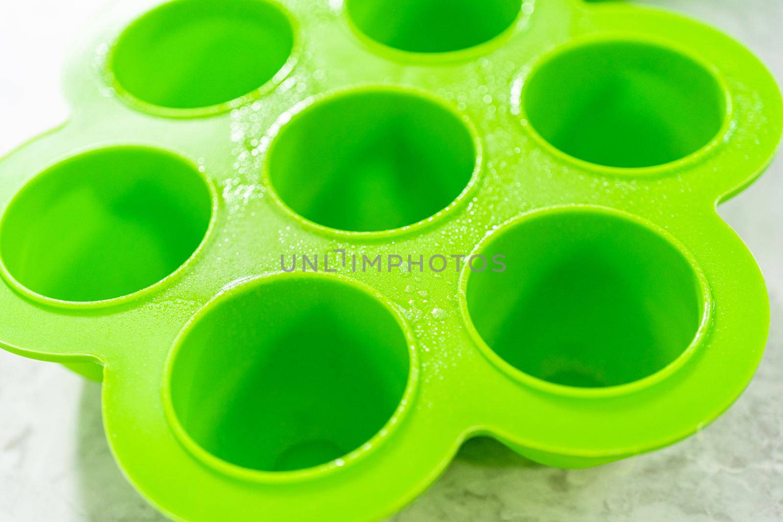 Filling silicone molds with egg mixture to make egg bites in a pressure cooker.