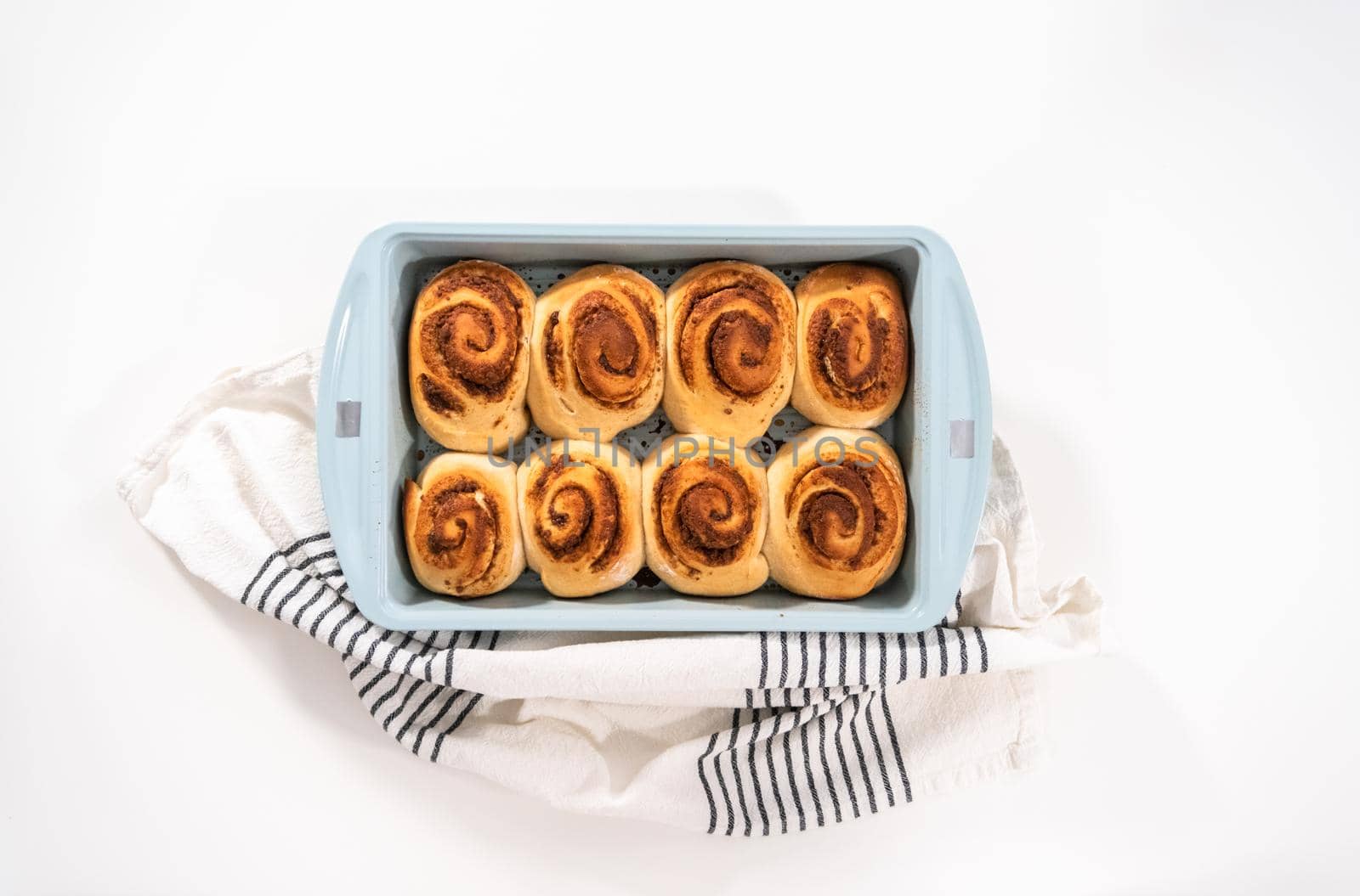 Freshly baked cinnamon rolls in a blue baking pan.