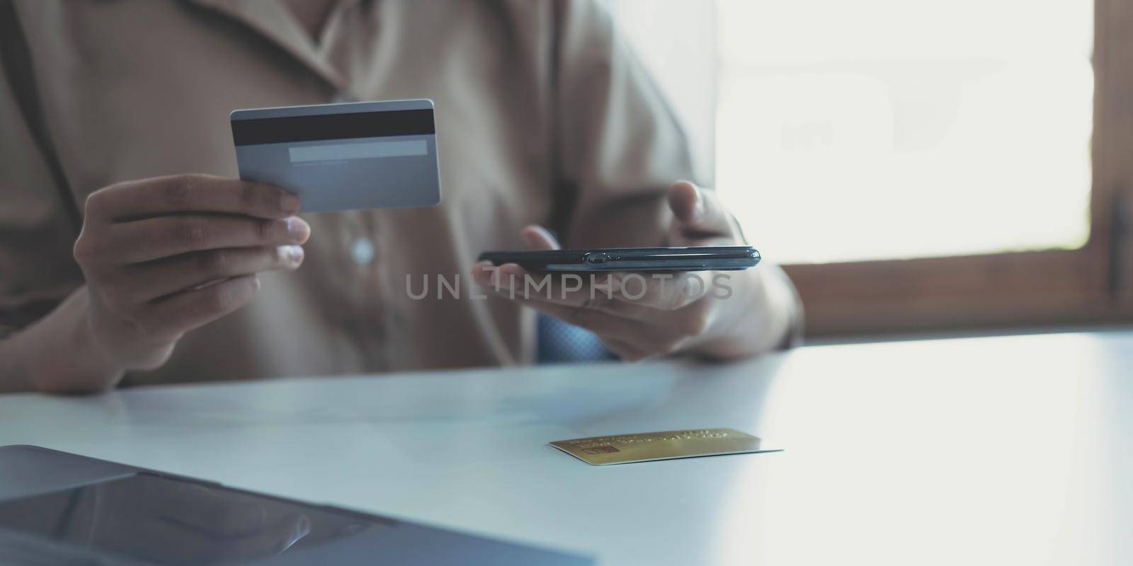 Woman hands holding smartphone shopping online with credit card. Online Payment. Online shopping concept. by wichayada