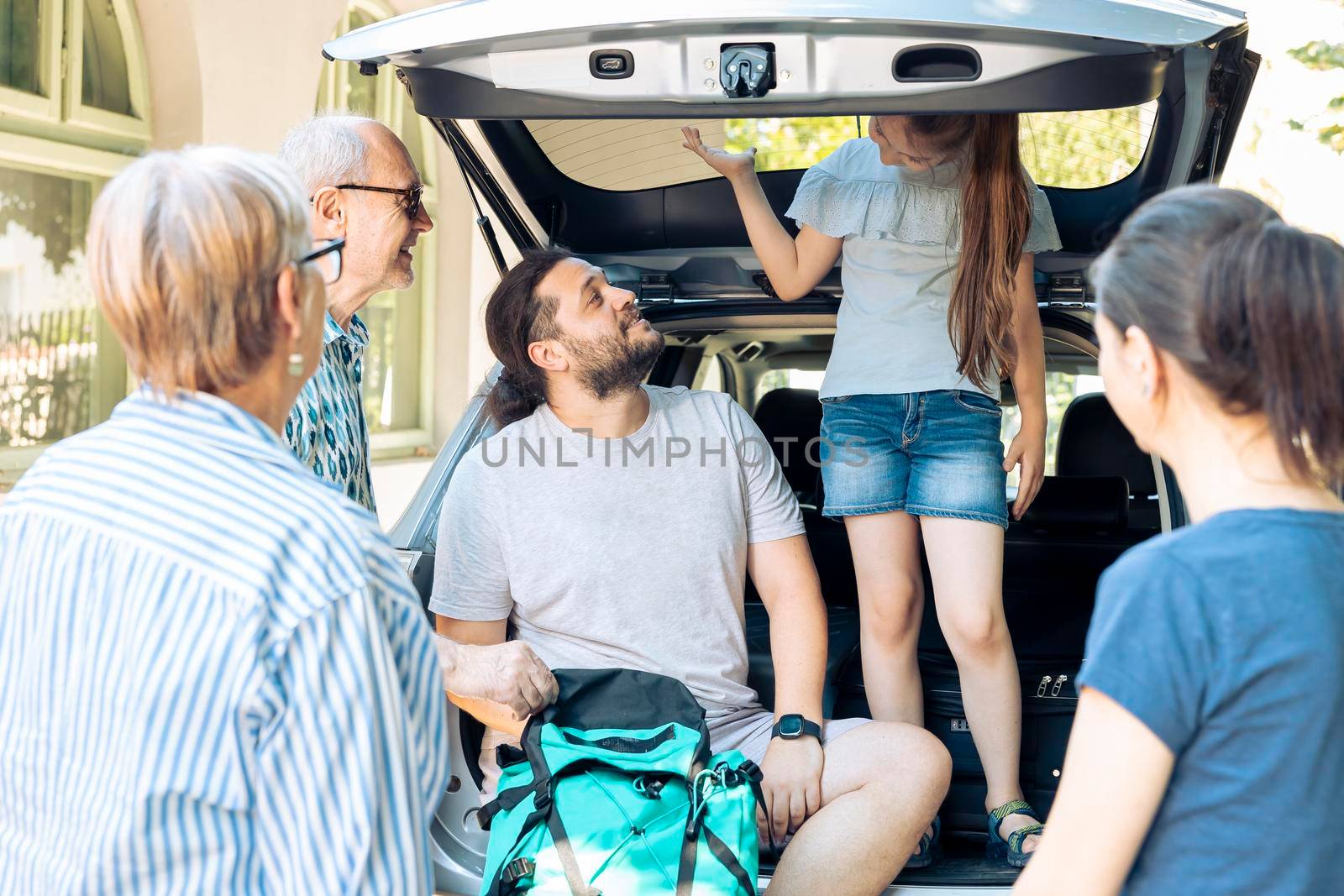 European people travelling on holiday vacation with little child, parents and grandparents. Going on summer journey at seaside with inflatable and travel bags, leaving with luggage and suitcase.