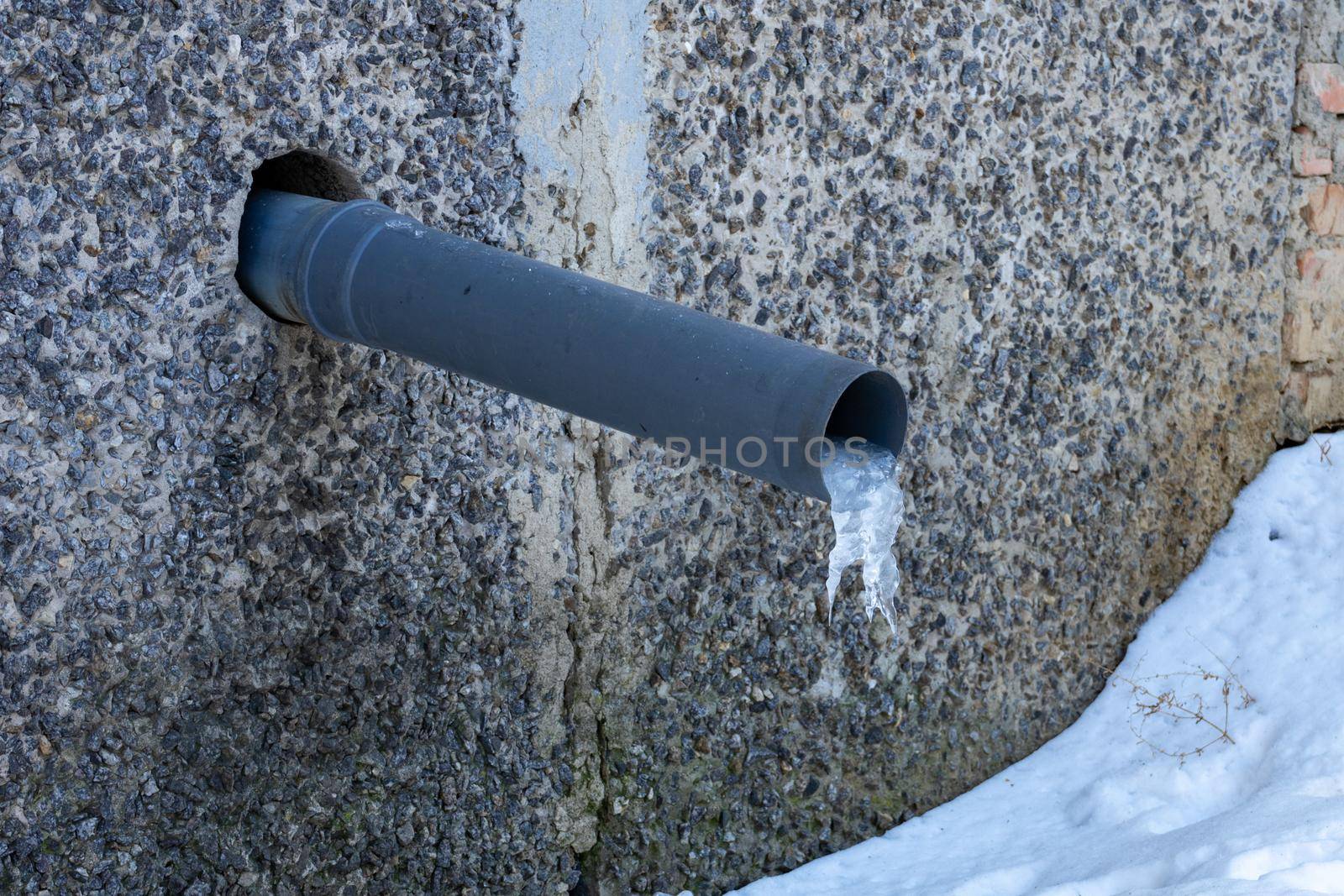 A water pipe in a house with a frozen piece of ice. rainwater harvesting