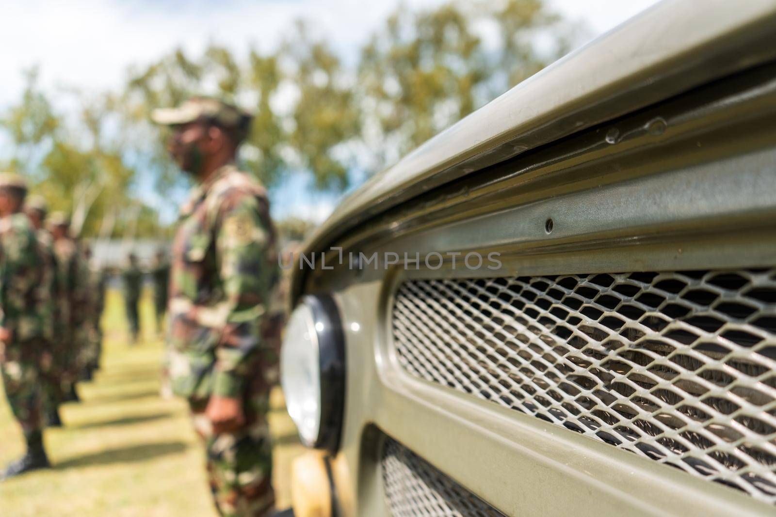 Military vehicle in the foreground with Latino soldiers out of focus by cfalvarez