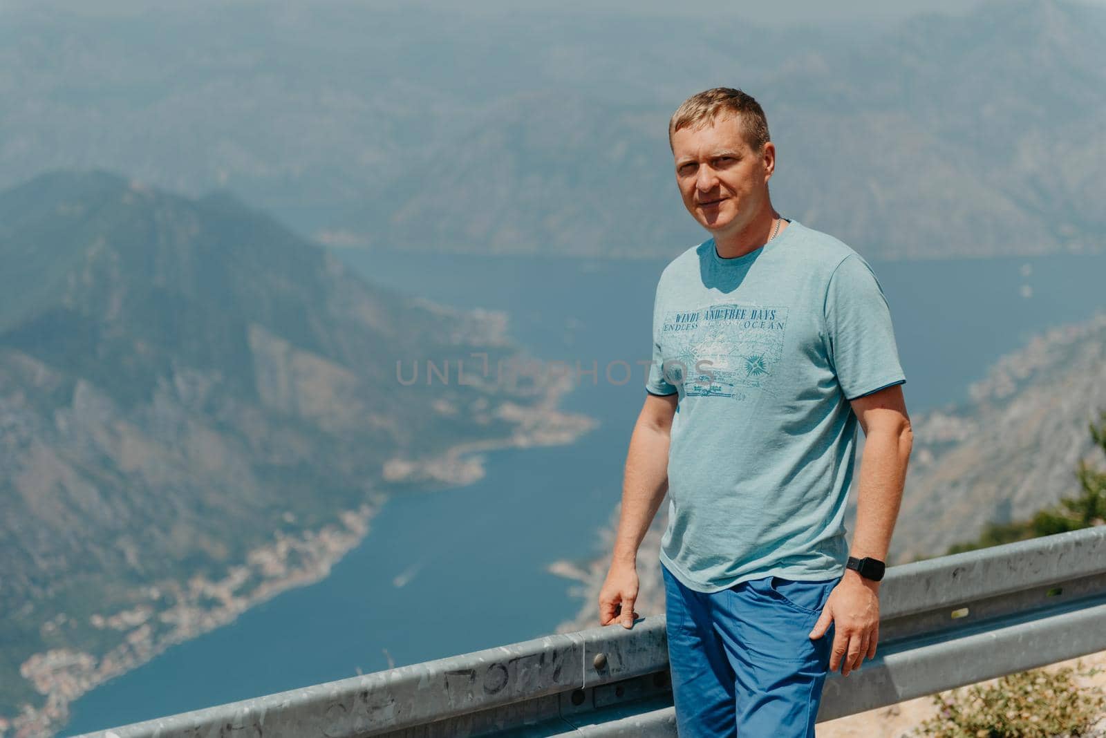 Man tourist enjoys the view of Kotor. Montenegro. Bay of Kotor, Gulf of Kotor, Boka Kotorska and walled old city. Travel to Montenegro concept. Fortifications of Kotor is on UNESCO World Heritage by Andrii_Ko