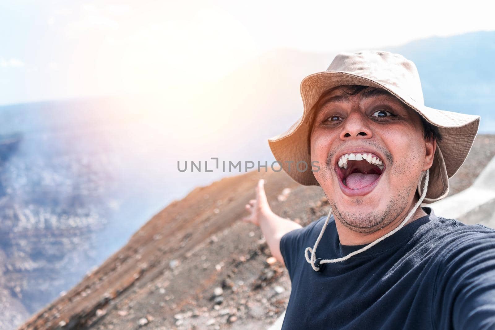 Latin man smiling taking a self portrait visiting a volcano in Masaya Nicaragua