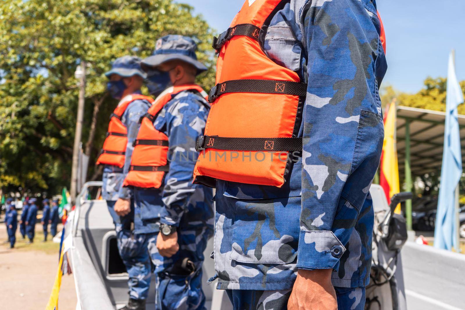 Unrecognizable naval force soldiers wearing life jackets standing firm