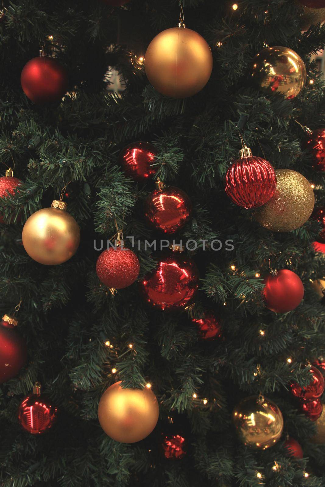 Christmas ornaments in red and gold on display in a Christmas shop by studioportosabbia