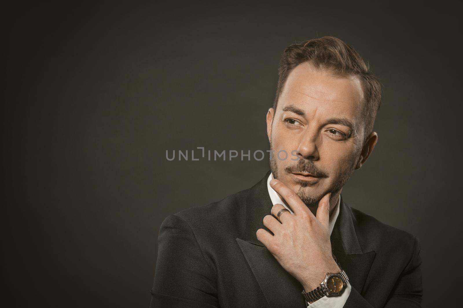 Businessman think studio in modern style on black background. Business man isolated portrait. Black background. Beautiful model. People lifestyle concept. Attractive fashion model.