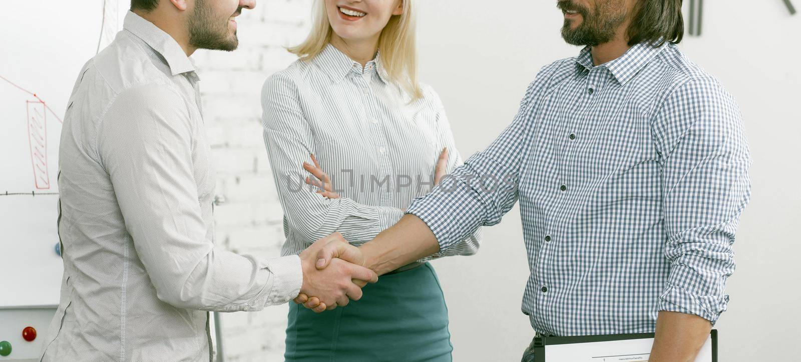 Business partners shaking hands in agreement. Greeting colleagues shaking hands, businessmen greeting each other shaking hands. Cropped shot. Toned image.