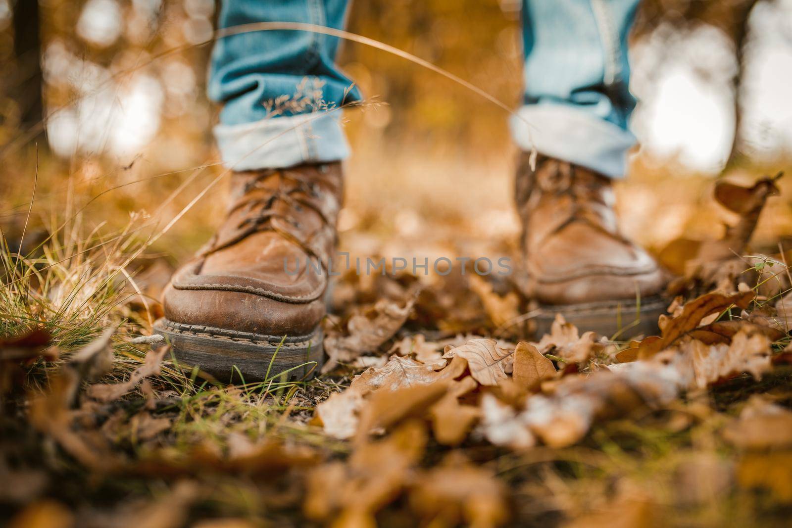 Man's Legs Walking On Autumn Leaves by LipikStockMedia