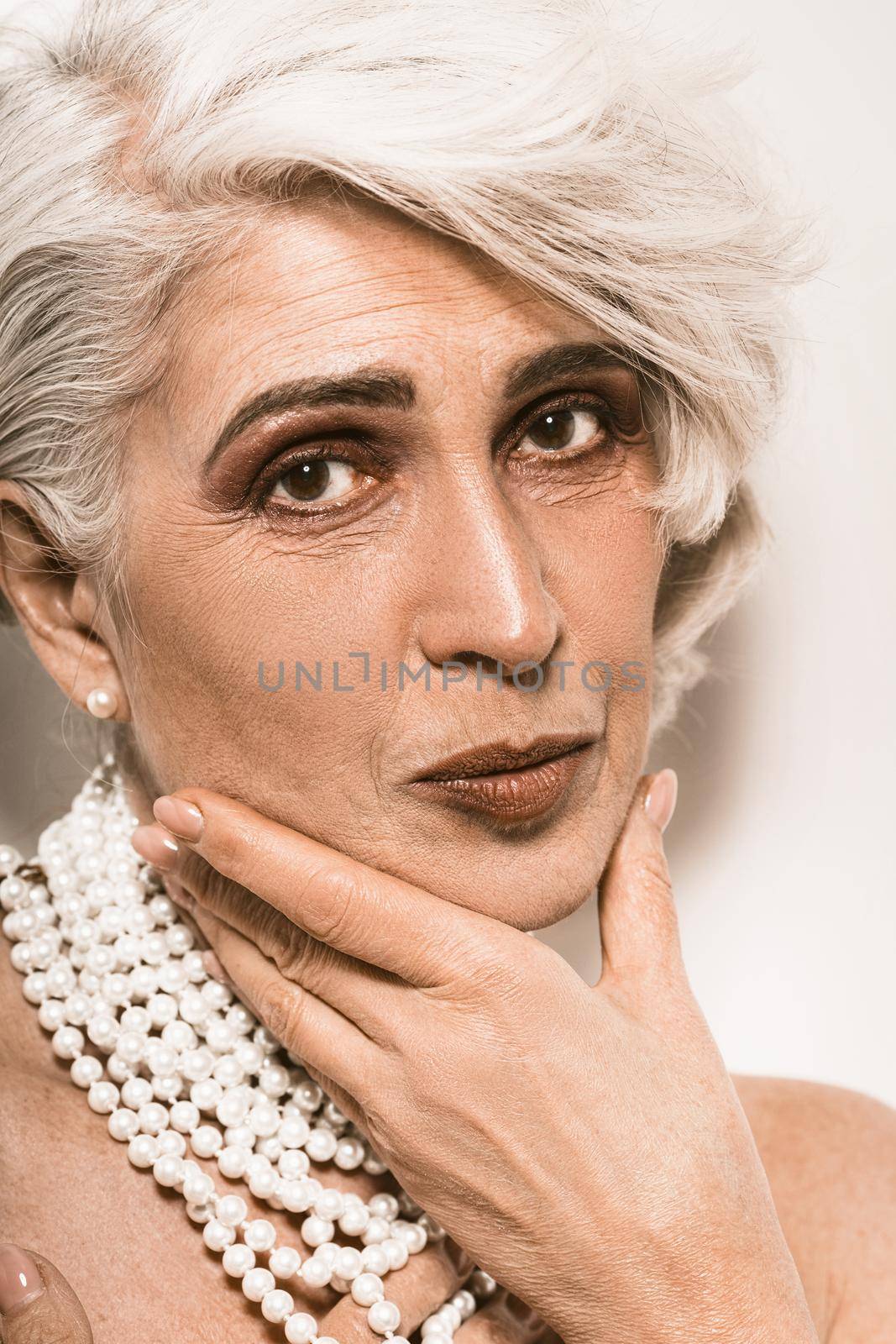 Portrait on white backdrop. Healthy lifestyle. Skin care. Older people. Fashion model. Beauty face.