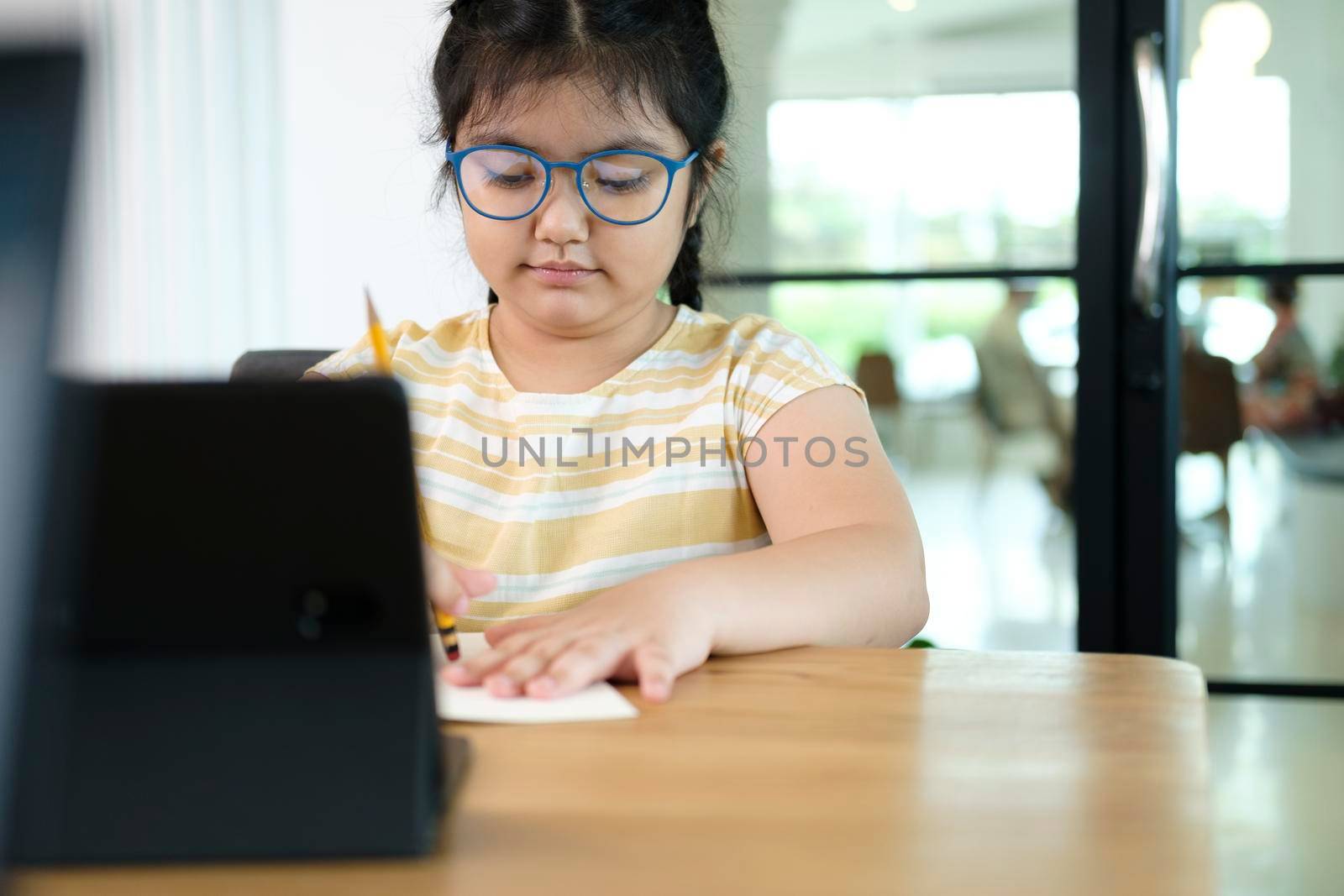 Cute and happy little girl children using laptop computer, studying through online e-learning system.