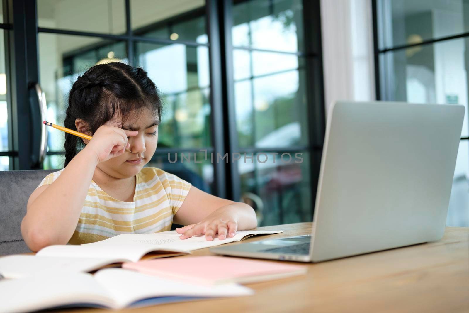 Cute and happy little girl children using laptop computer, studying through online e-learning system.