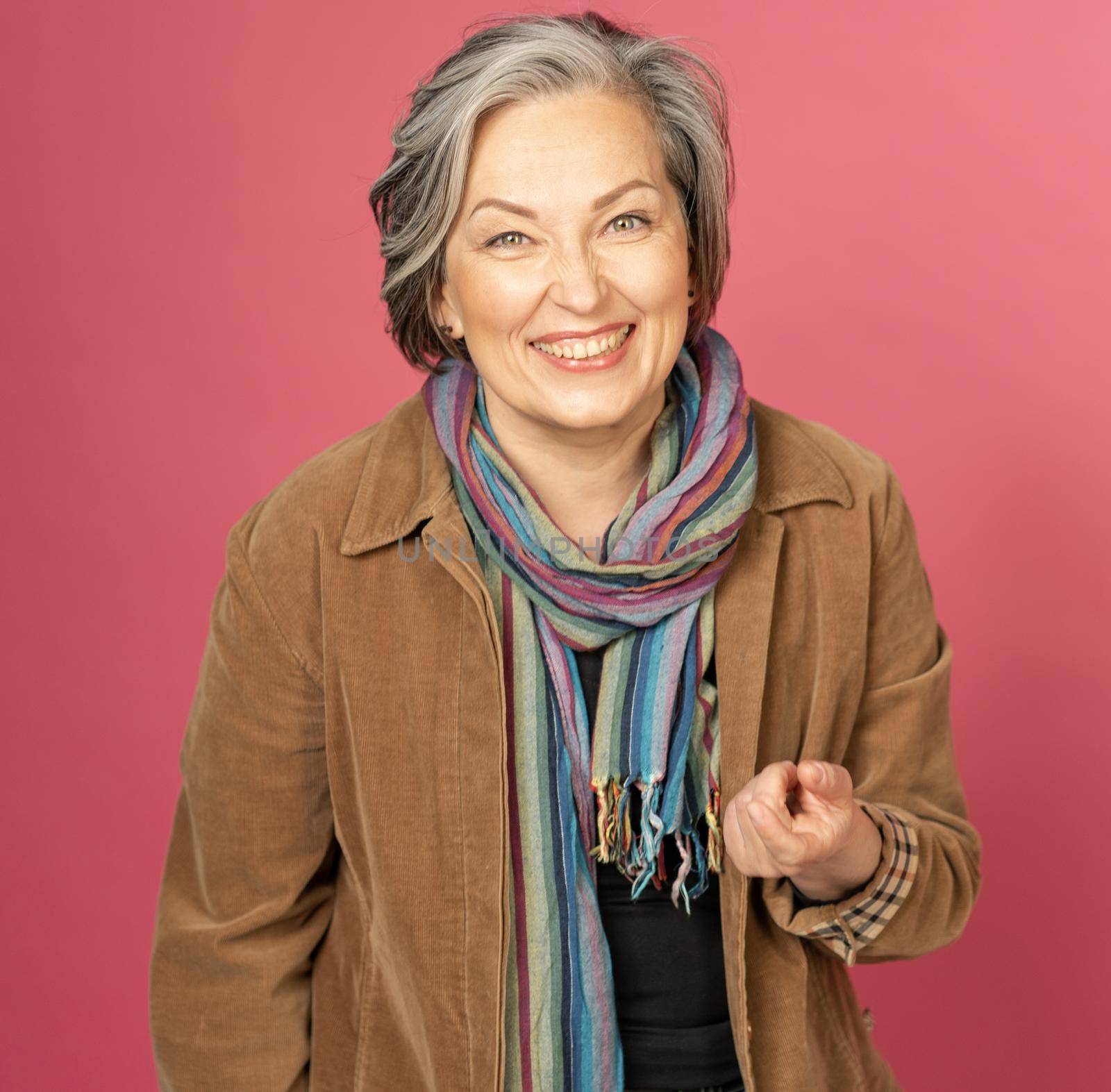 Stylish mid-aged woman laughs happily into camera. Laughing silver haired woman enjoing by life. Joy concept.