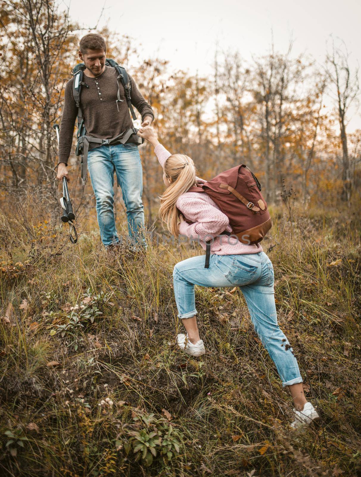 Friendly Couple Of Tourists Rises To Hill by LipikStockMedia