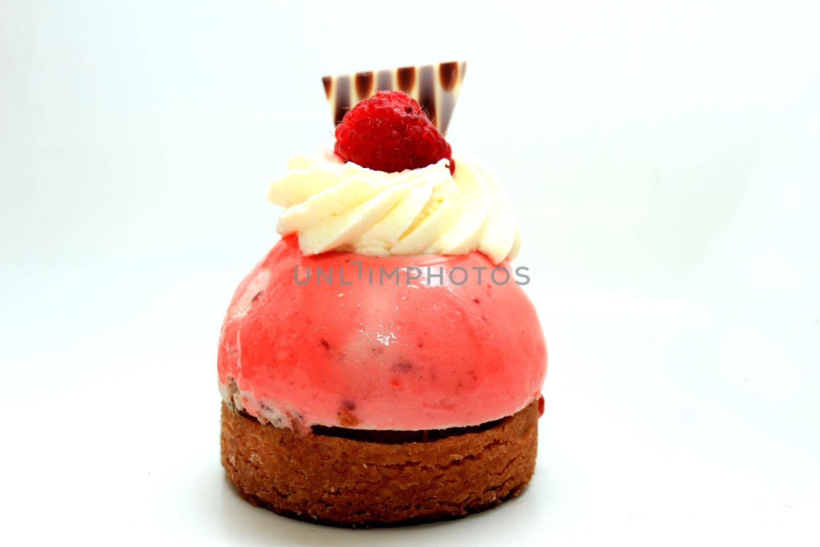 Fresh raspberry mousse confectionery, with cream and a chocolate decoration by studioportosabbia