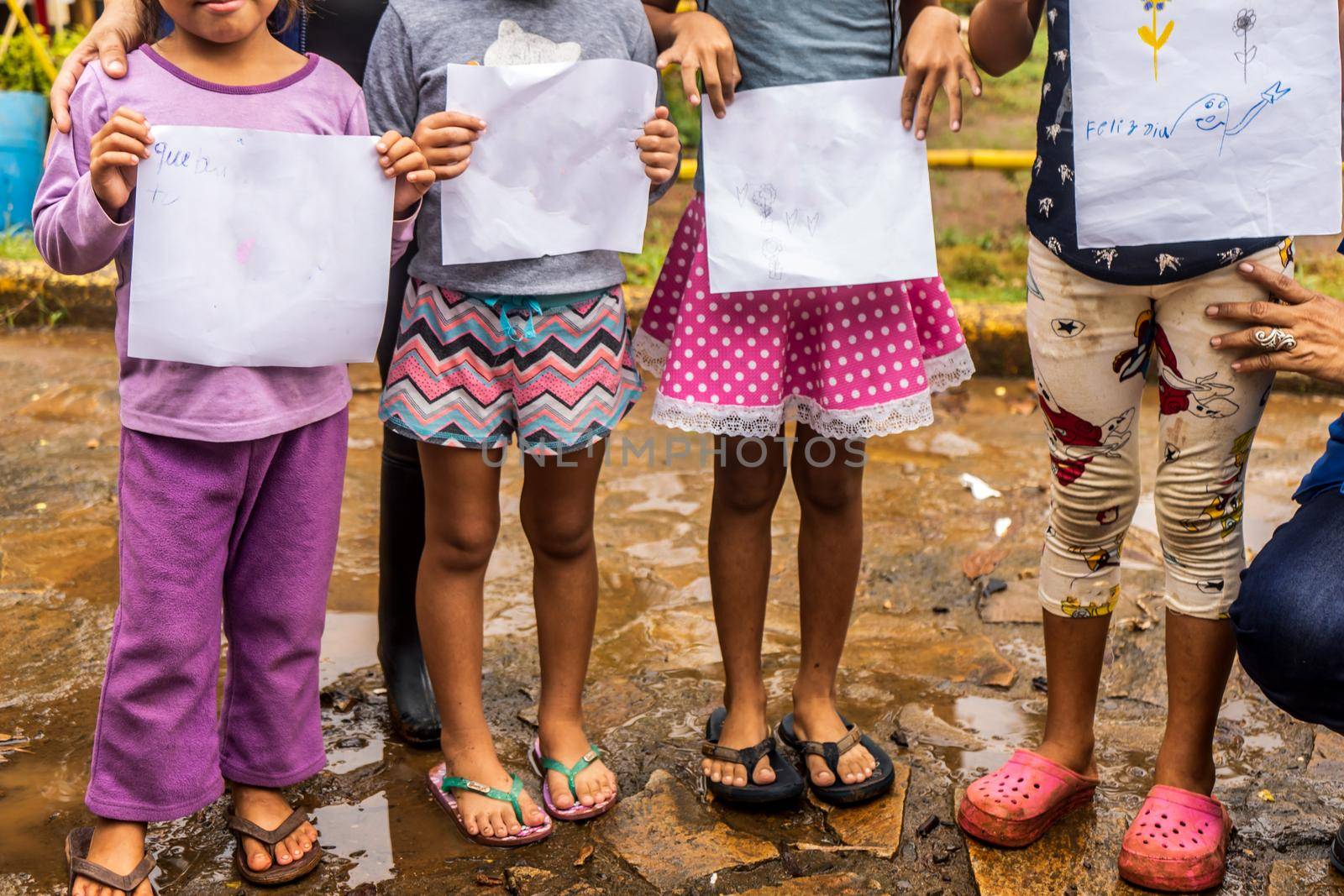 Group of dabnified children showing blank papers where they drew pictures in El Rama, Nicaragua