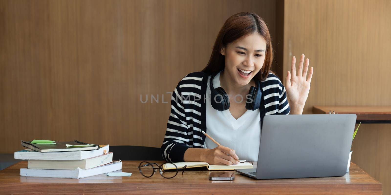 Back to school concept. Young college woman using laptop at library.